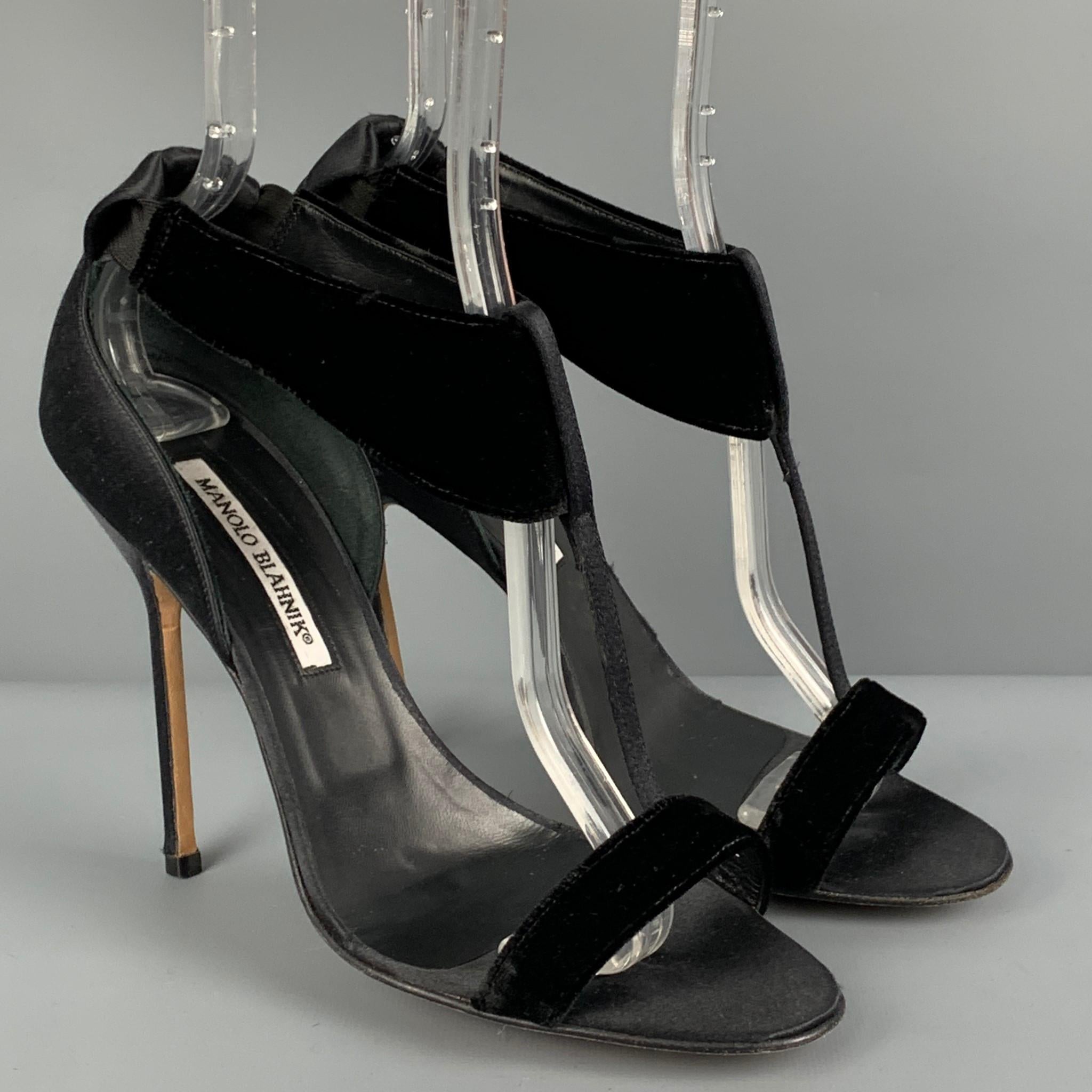 MANOLO BLAHNIK sandals comes in a black satin with a velvet trim featuring a t-strap style, open toe, and a stiletto heel. Made in Italy. 

Very Good Pre-Owned Condition.
Marked: 39

Measurements:

Heel: 4.5 in. 