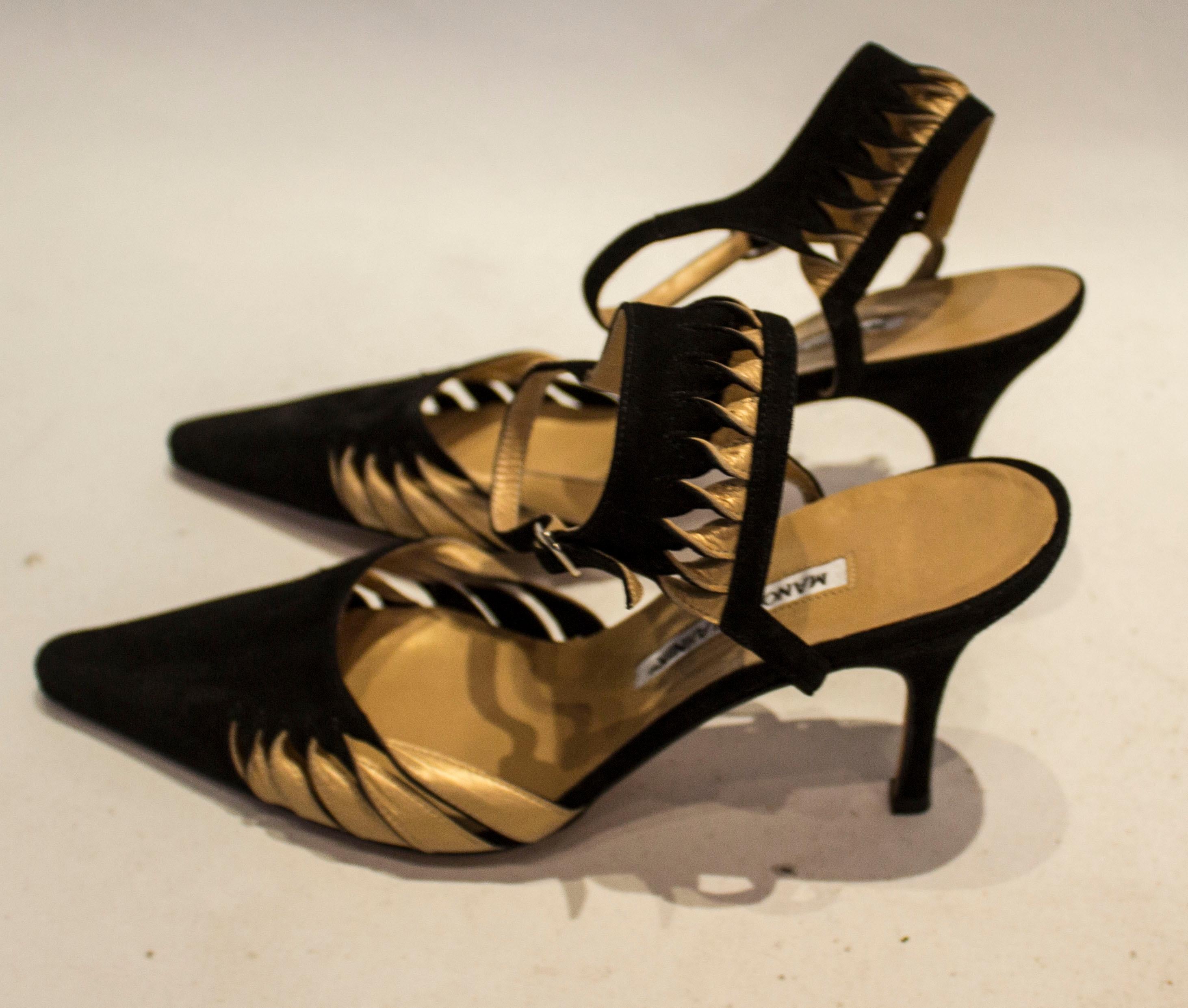 A chic pair of shoes , in black suede and gold leather. The shoes have an attractive ankle strap , are lined in gold leather and have a 4'' heel. Marked size 39 1/2.