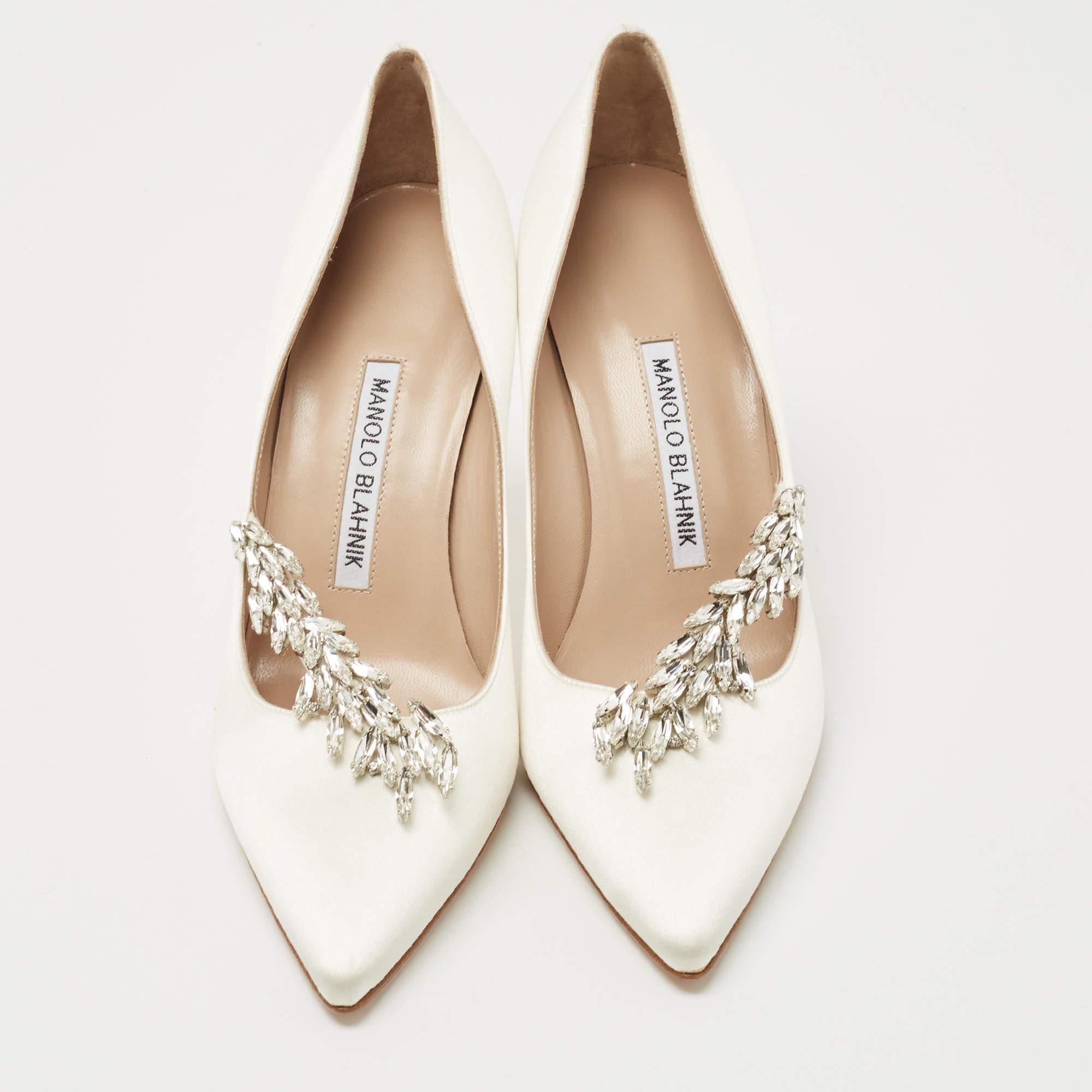 Manolo Blahnik is well-known for his graceful designs, and his label is synonymous with opulence, femininity, and elegance. These Nadira pumps are crafted from satin in a white hue into a pointed toe silhouette augmented by dazzling crystal