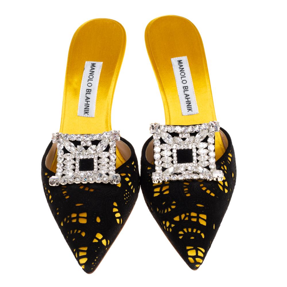 Look elegant and fashionable in these Manolo Blahnik Borli mules. Crafted from yellow satin and black suede, they feature pointed toes and laser-cut vamps that are adorned with crystal embellishments. They come equipped with comfortable insoles and