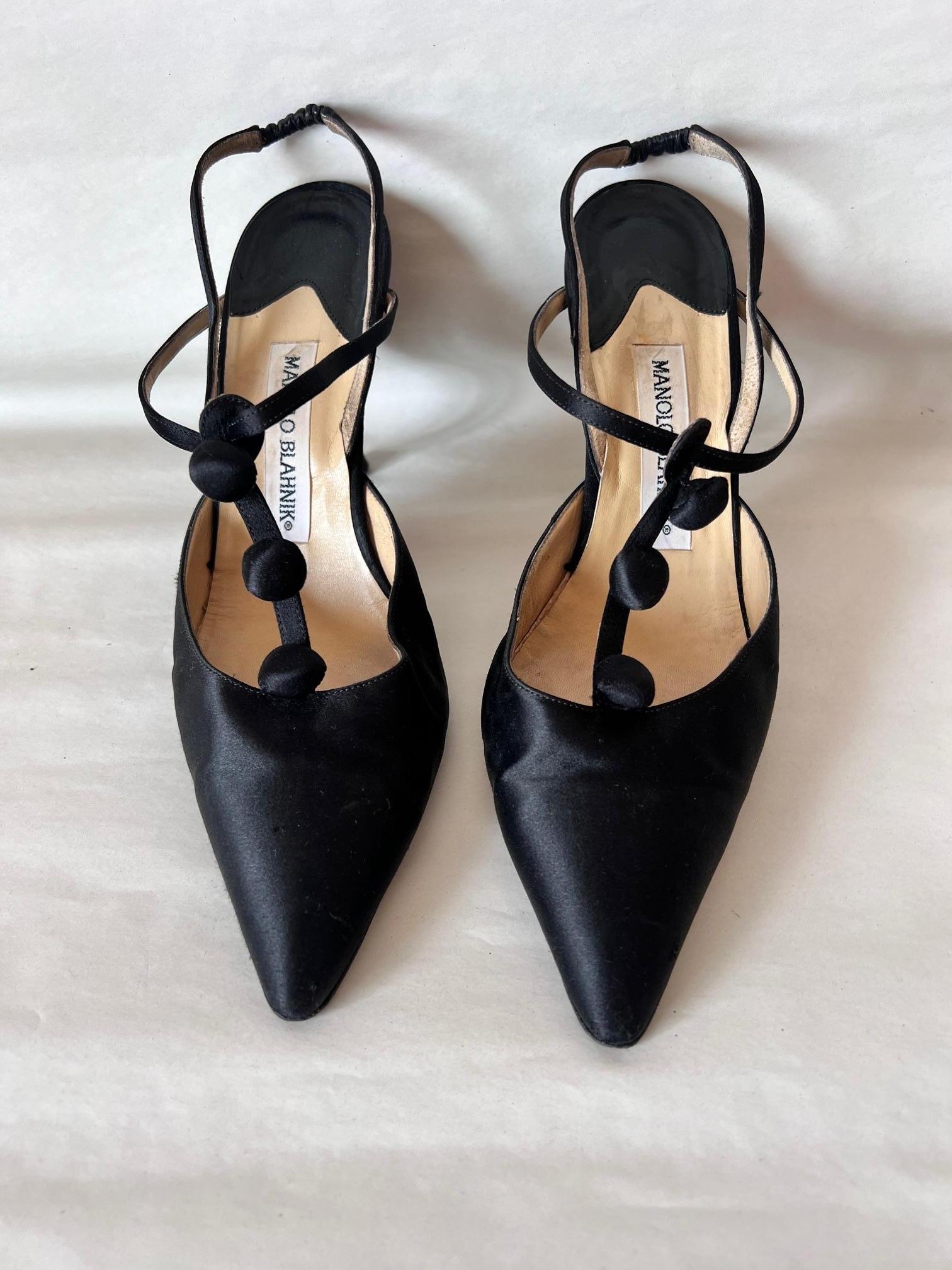 Manolo Blanick Black Satin Button Up  Cocktail  Open Back Shoes
Made In: Italy
Color: Black
Material: Satin 
Marked Size: 39,5 Europe
Heel Height: 8 cm/ 3,14 inches

His name has become synonymous with women’s luxury shoes, yet Manolo Blahnik is a