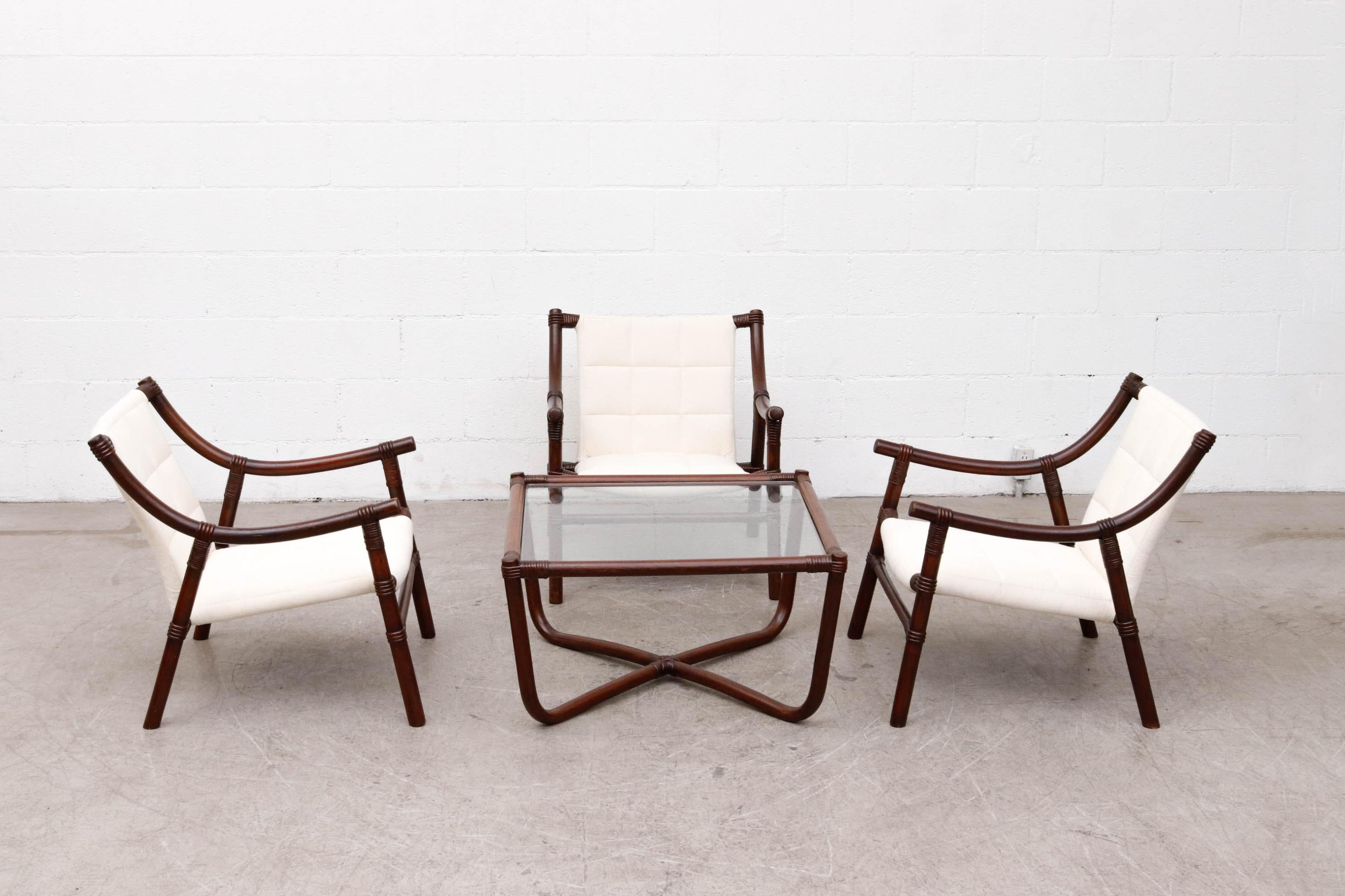 Mid-century Manou dark stained bamboo lounge chair with new white canvas and matching table with inset glass . In good overall condition with wear consistent with their age. Shot with matching bamboo table with inset glass side or coffee table .