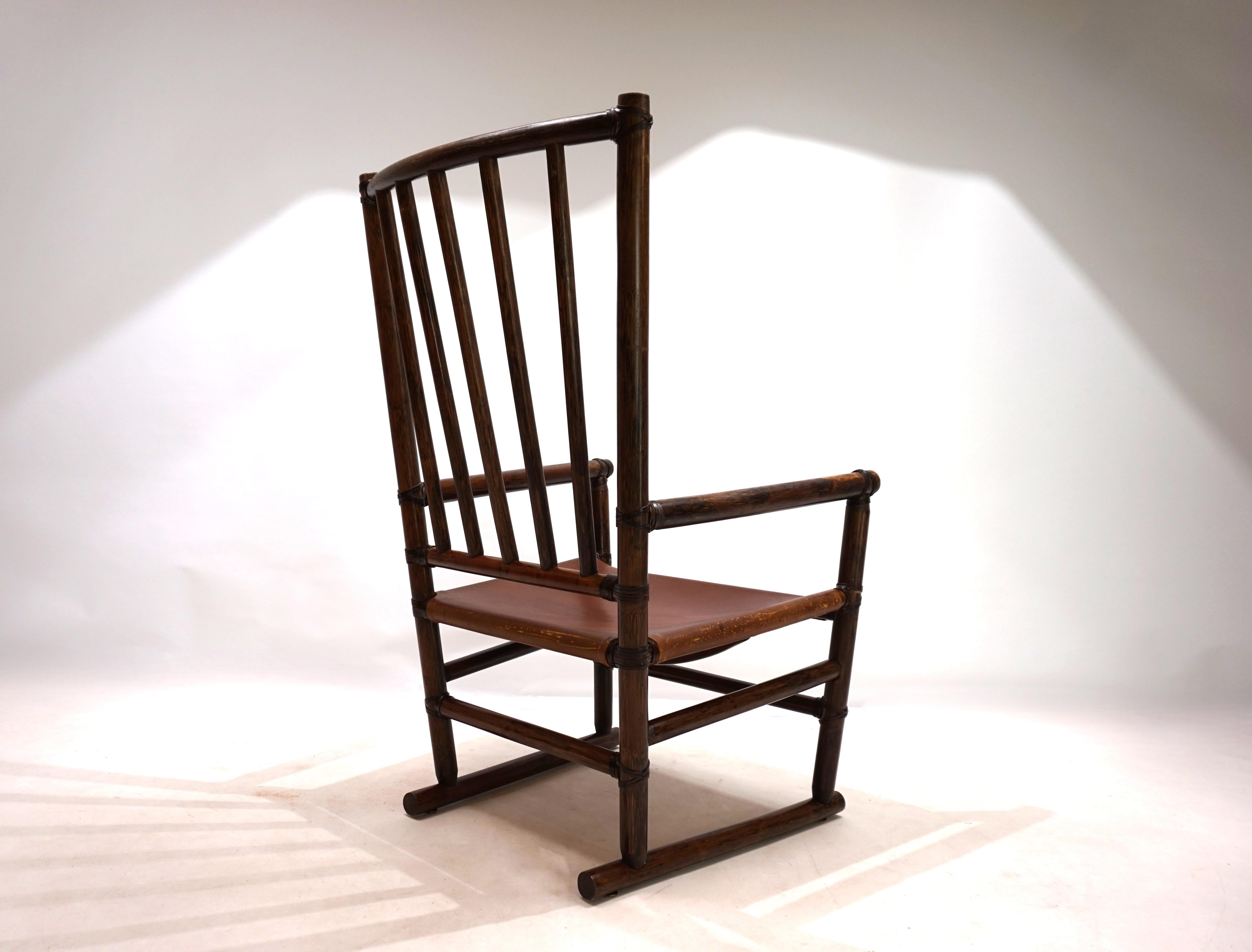 La chaise longue, en rotin de Manou, est en excellent état. Le cadre en rotin Manou teinté foncé présente une superbe patine. Les tiges du dossier et les connecteurs de l'anche sont impeccables et intacts. La chaise est dotée d'une assise en cuir