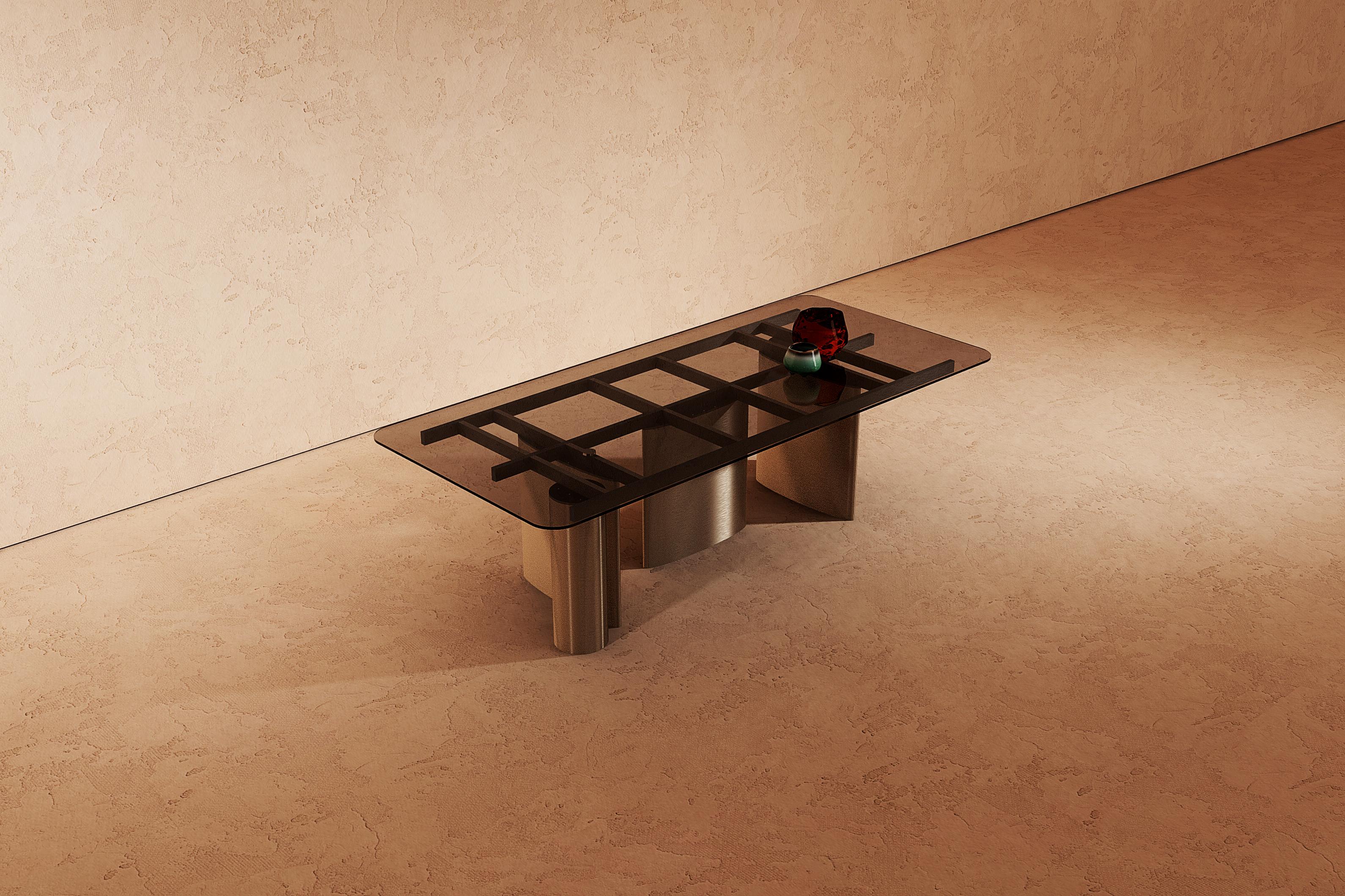 The Manson table, unique in its category., with its painted metal frame, timeless shapes and unconical volumes, the smoked glass top lets the user admire the underlying structure, made of galvanized metal finished in matte black.