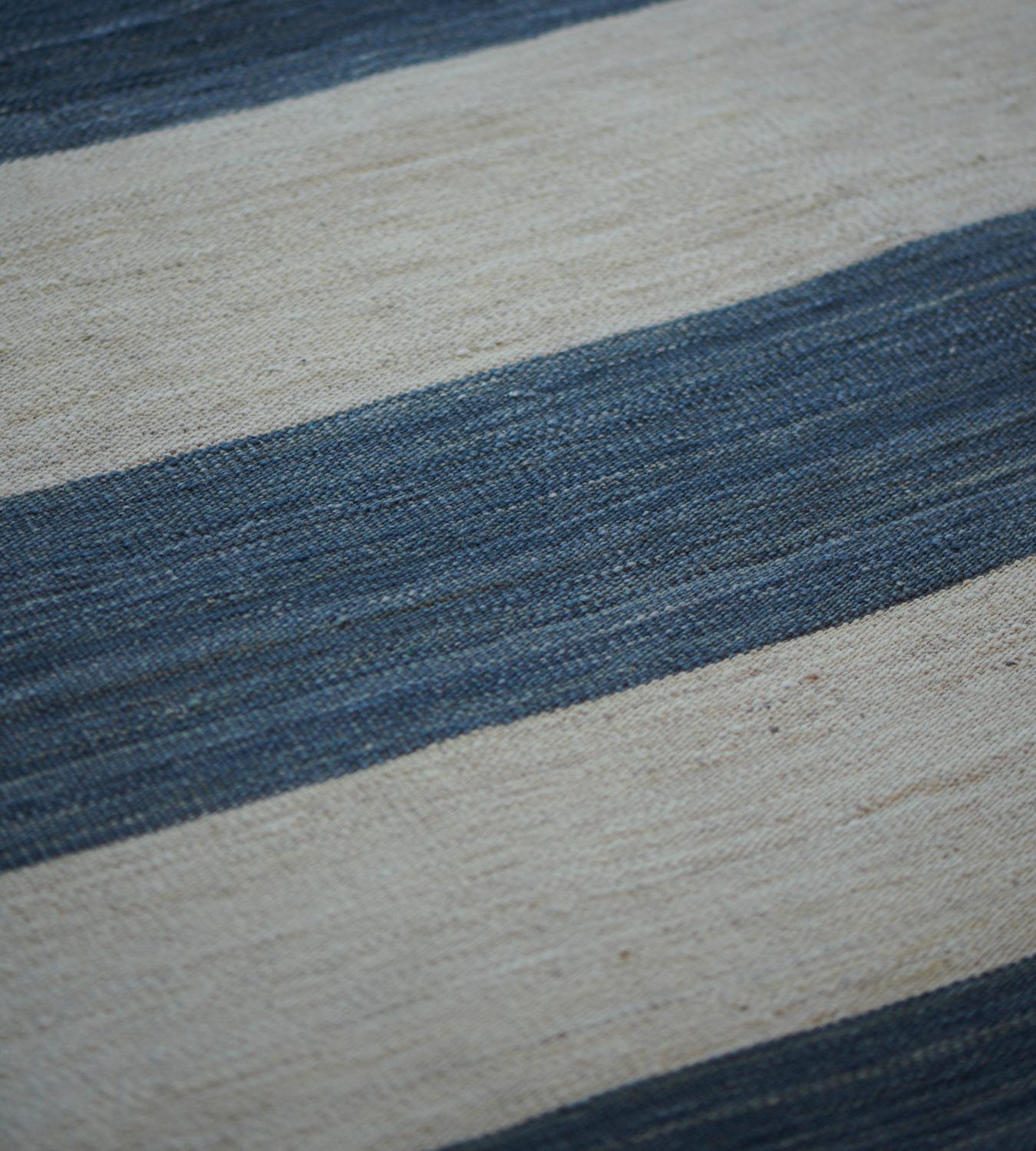 Masterful flat-weave construction creates an ideal canvas to appreciate the tonal nuance of this handwoven striped wool Mansour Modern rug.