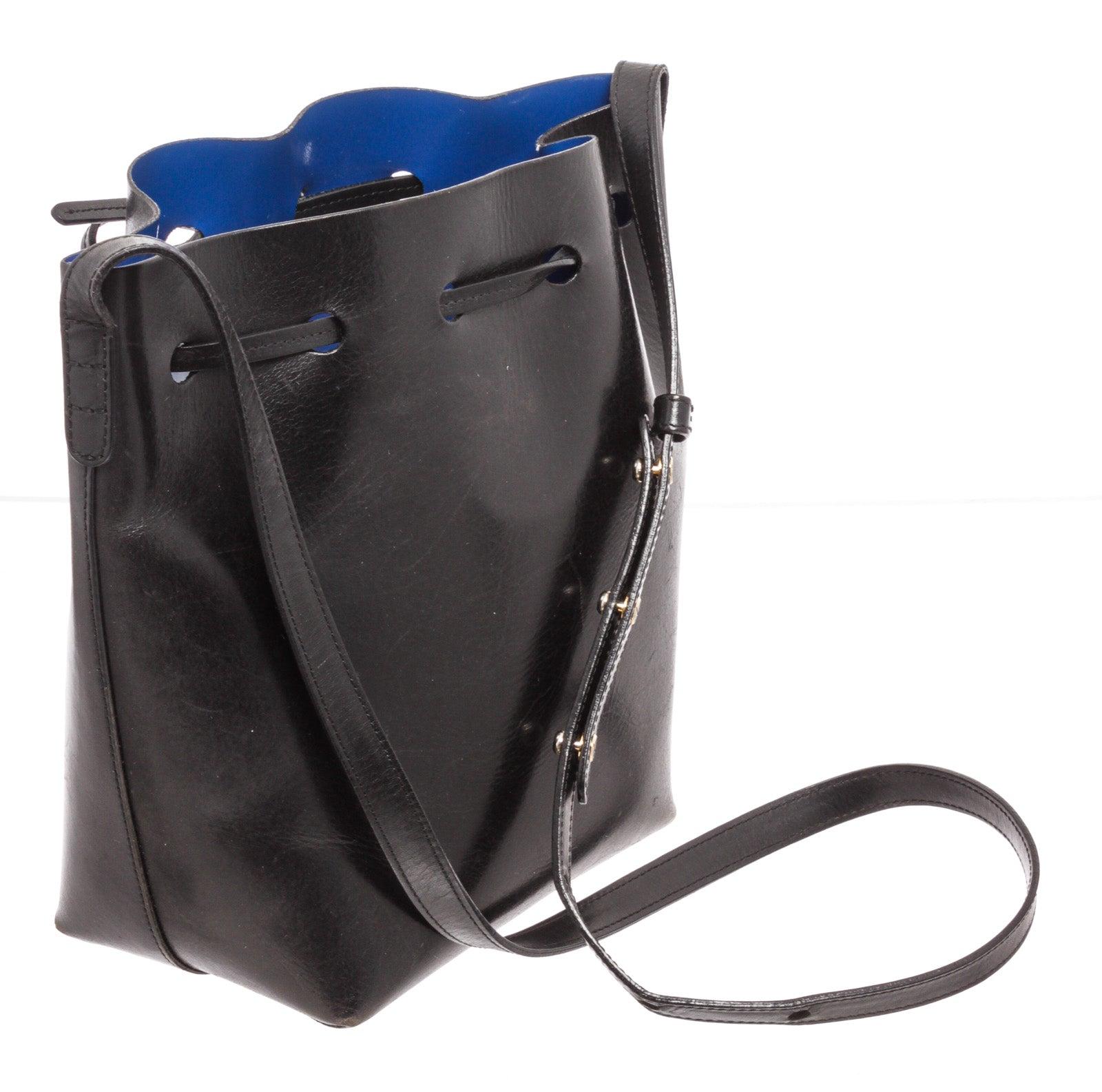 Mansur Black Leather Gavrial Bucket Bag with gold-tone hardware, leather trim, radjustable shoulder strap, canvas lining & interior pockets, drawstring closure.
30784MSC