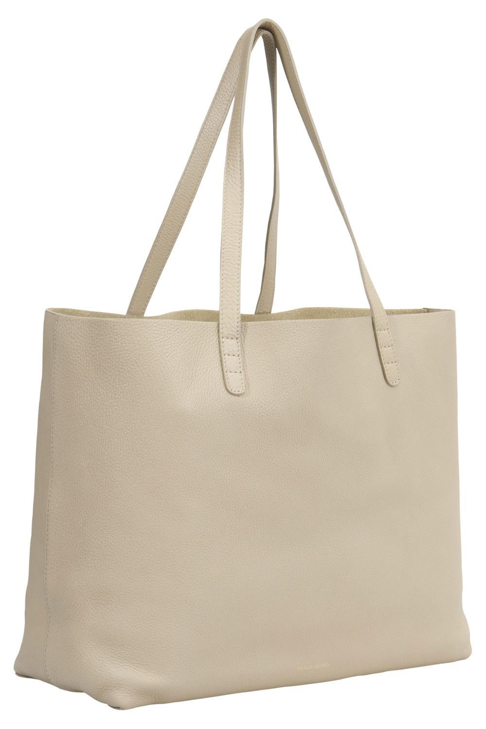 The tote from Mansur Gavriel is a timeless piece. The leather bag comes in a luxurious beige hue with gold-tone hardware. It features double top handles. The bag opens to reveal a spacious interior with enough space to easily hold your necessities.