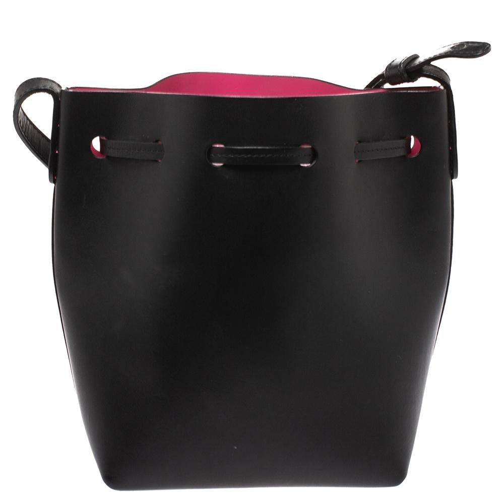 This wonderful Mansur Gavriel design is made from leather and enhanced with gold-tone hardware. The bag has a bucket shape with a drawstring closure that secures the leather interior. It is complete with a shoulder strap. Black in shade, it is an