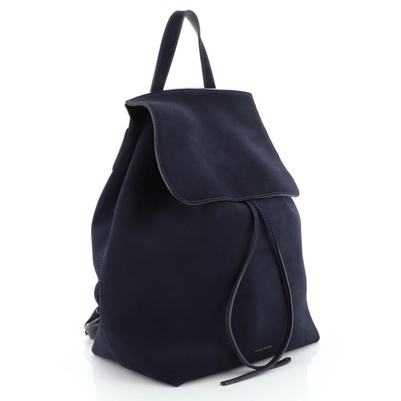This Mansur Gavriel Drawstring Backpack Suede Mini, crafted from blue suede, features a looped top handle, adjustable backpack straps, and gold-tone hardware. Its flap and drawstring closures open to a blue leather interior with side zip pocket.