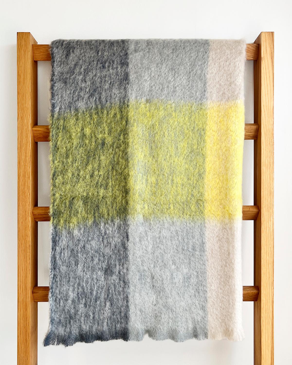 Ce luxueux plaid en mohair à carreaux gris et jaunes est parfait pour égayer instantanément tout décor. Doux et confortable au toucher, il présente un mélange de jaune lime vif et de teintes gris foncé et gris clair dans un motif à carreaux moderne.