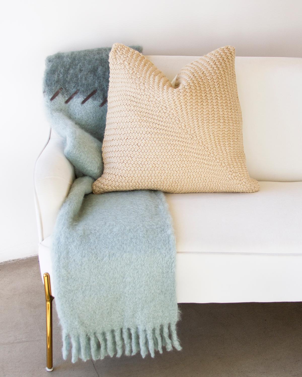 This cozy and warm Marina and Seafoam Mohair Throw is perfect for home décor. The soft and fuzzy mohair features a color block with blue-green and light aqua hues, designed to add a chic touch to any bedroom or living room. The suede whipstitch
