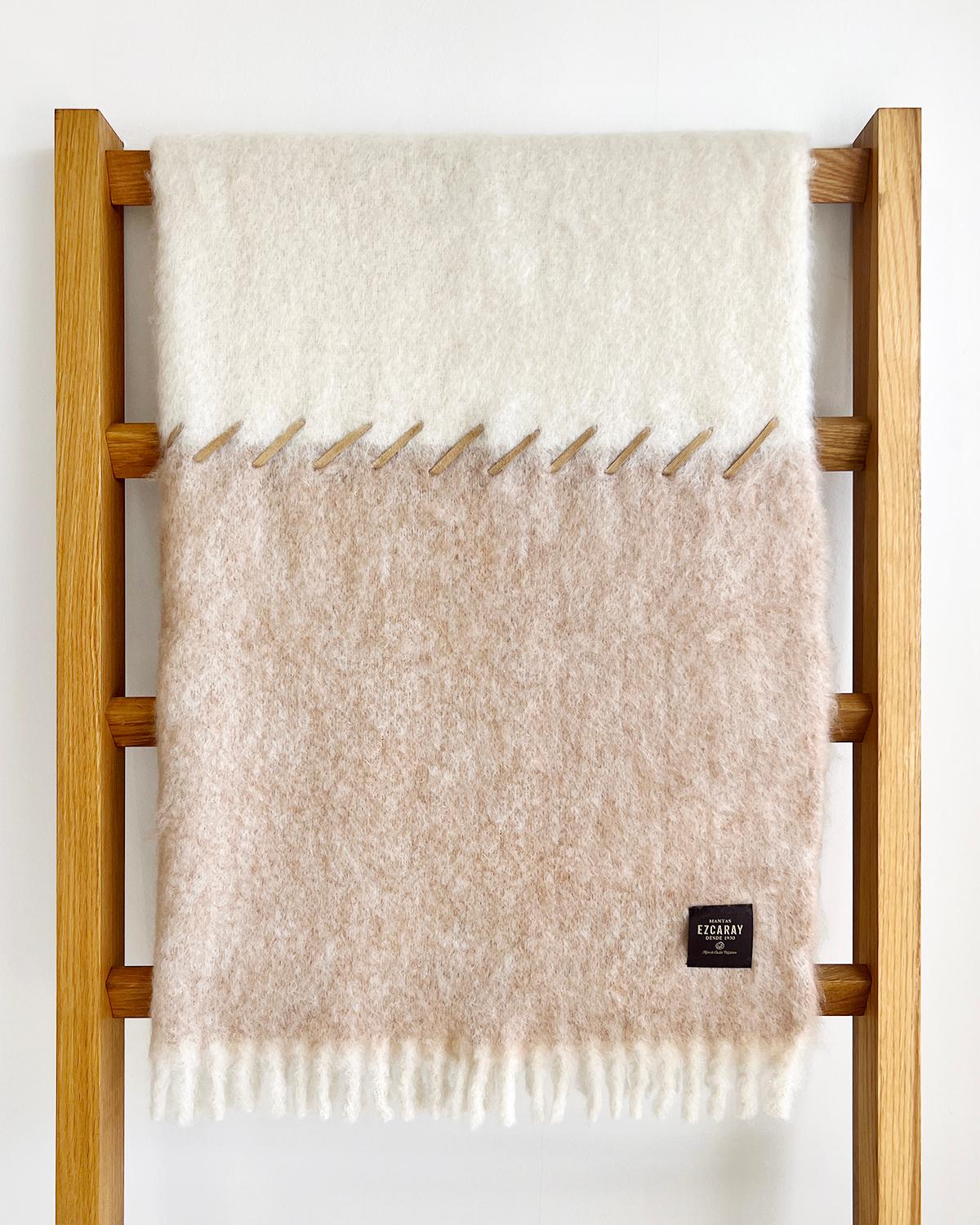 This Oatmeal and Cream Mohair Blanket is crafted with mohair and features two-toned beige and light brown colors with a suede whipstitch accent. It's soft and cozy, perfect for the winter season, and its classic design makes it an excellent addition