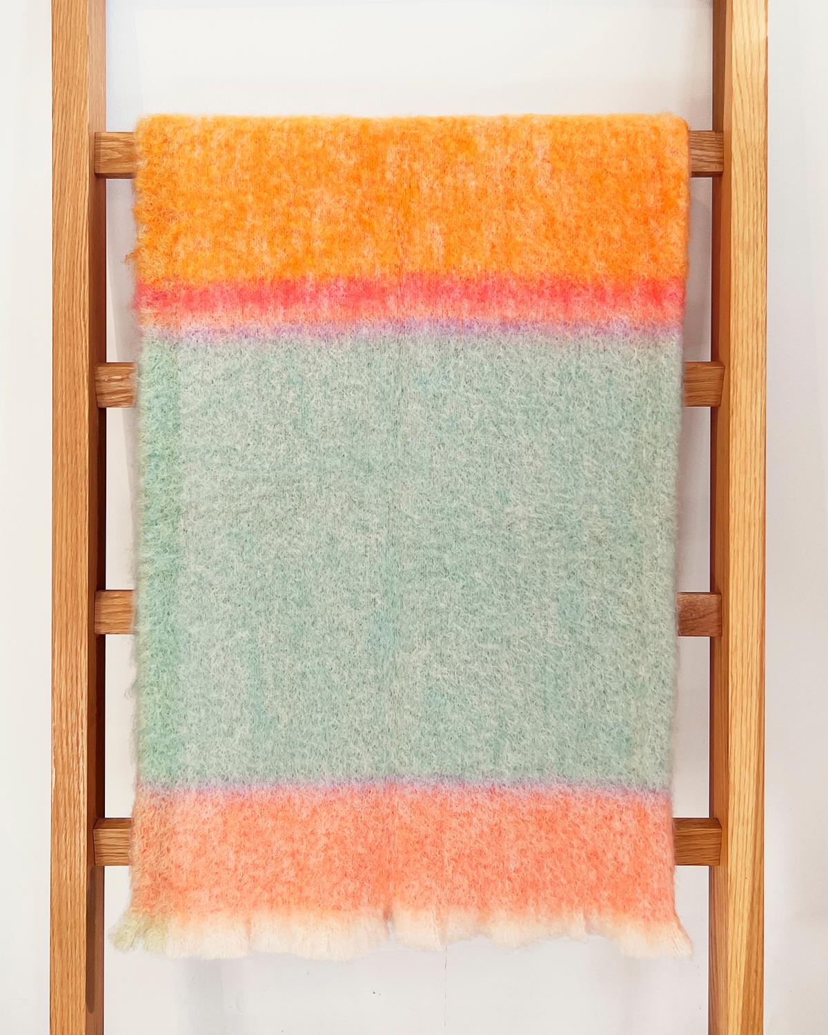 This handcrafted throw is an ideal addition to any interior. Made of luxurious mohair, it's ultra-soft and cozy, perfect for winter days. The bright colors—aqua, orange, pink, and lavender—will add a touch of maximalist flair to any living room or