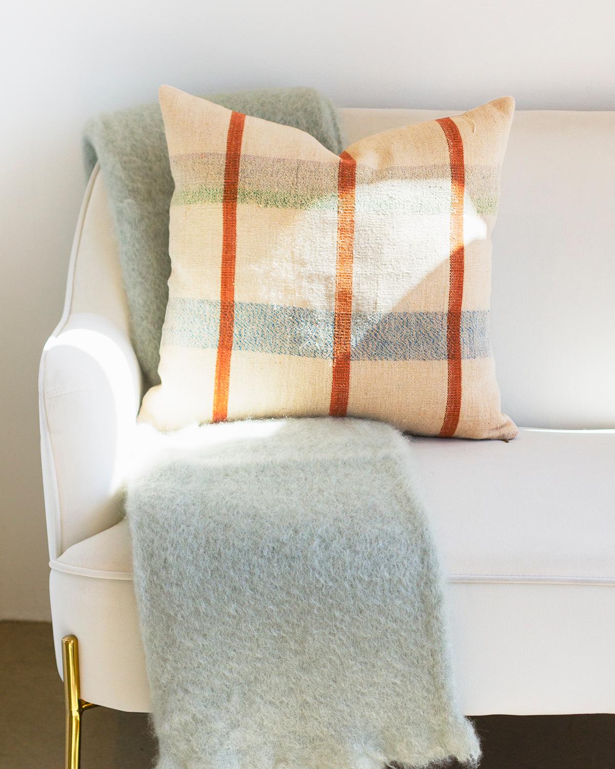 This Seafoam Mohair Blanket Throw provides a soft, cozy feel to warm up your winter. The light gray with a hint of greenish blue offers a unique, neutral look to any home, providing a quiet luxury. Each blanket is handmade from natural mohair,