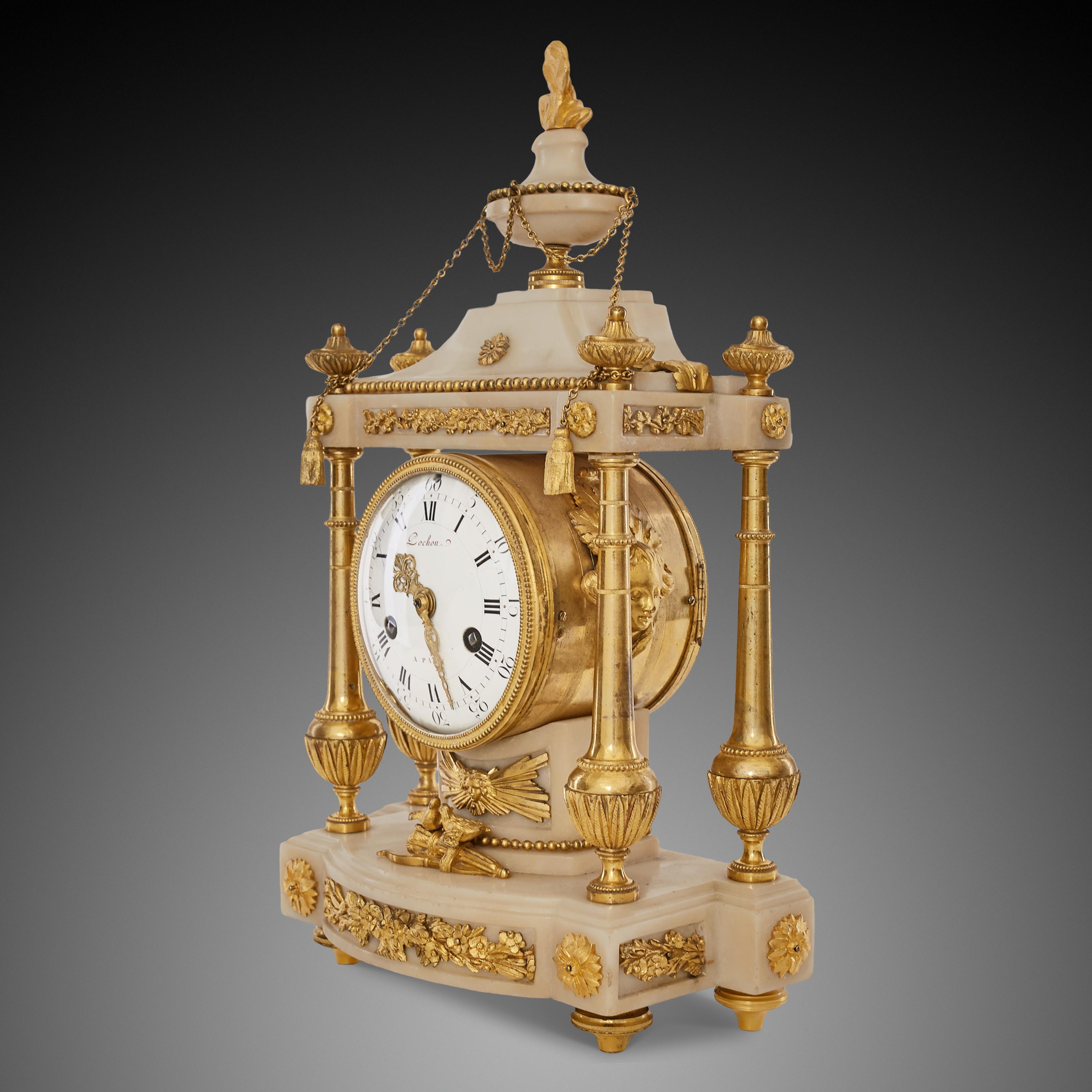 This Louis XV clock is richly decorated in gilded bronze and white marble.
The pillars, set in four delicate bronze consoles, are topped with leaf vases. This elegant decoration, columns made of white marble, rest on a marble base decorated with