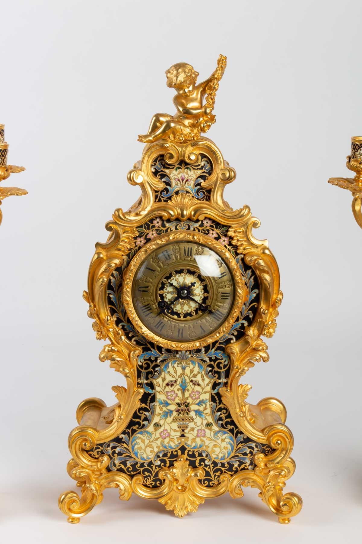 Mantel clock, 19th century, gilded bronze, enameled and cloisonné, Napoleon III
Pendulum: Height 50cm, width 26cm
Candelabra: Height 50cm, width 13cm.