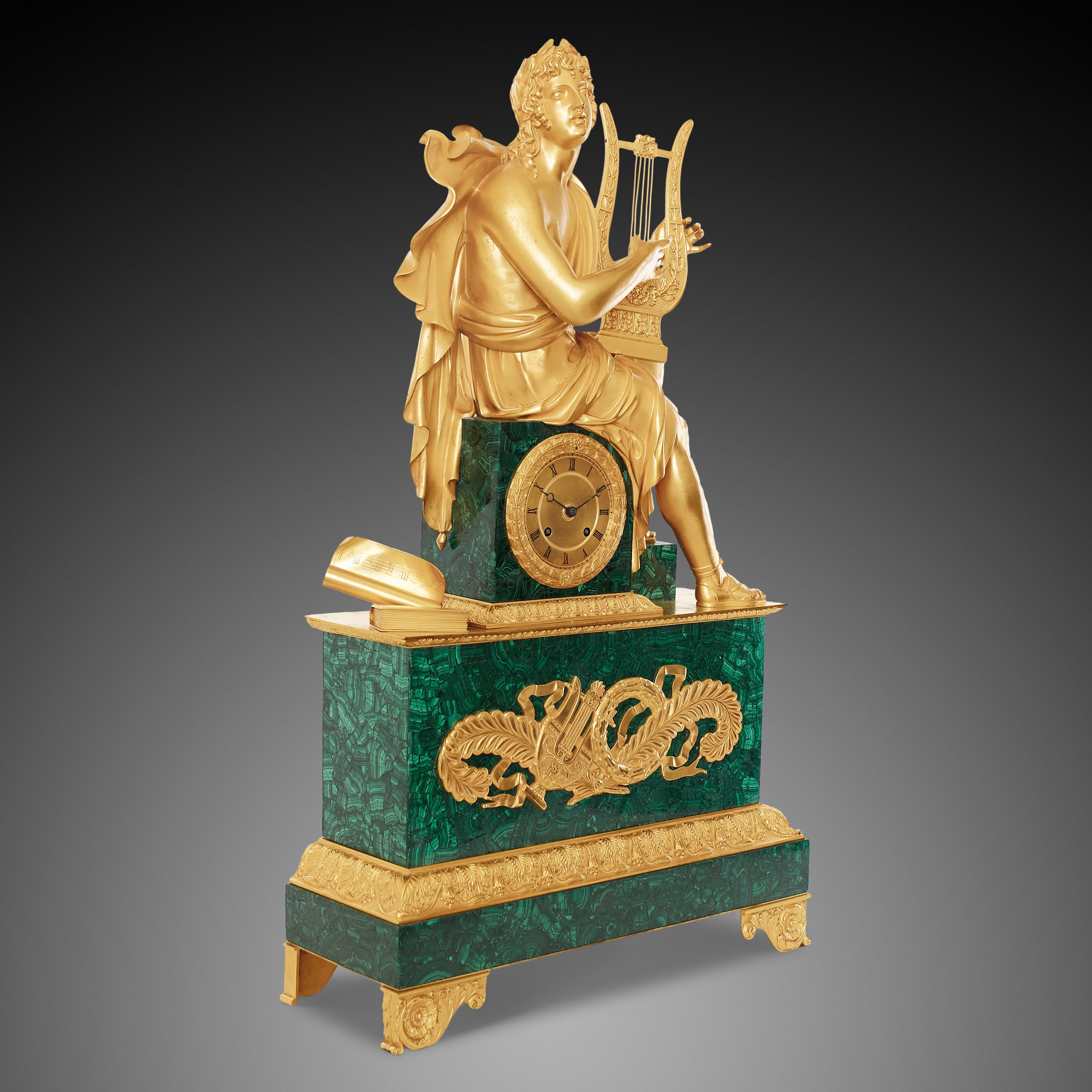 Mantel clock 19th century Louis Philippe Charles X period ormolu pendulum with malachite plinth. This stunning clock is surmounted by a gilded bronze figure of a Greek god – Apollo playing on a lyre, seated on the malachite square clock case draped