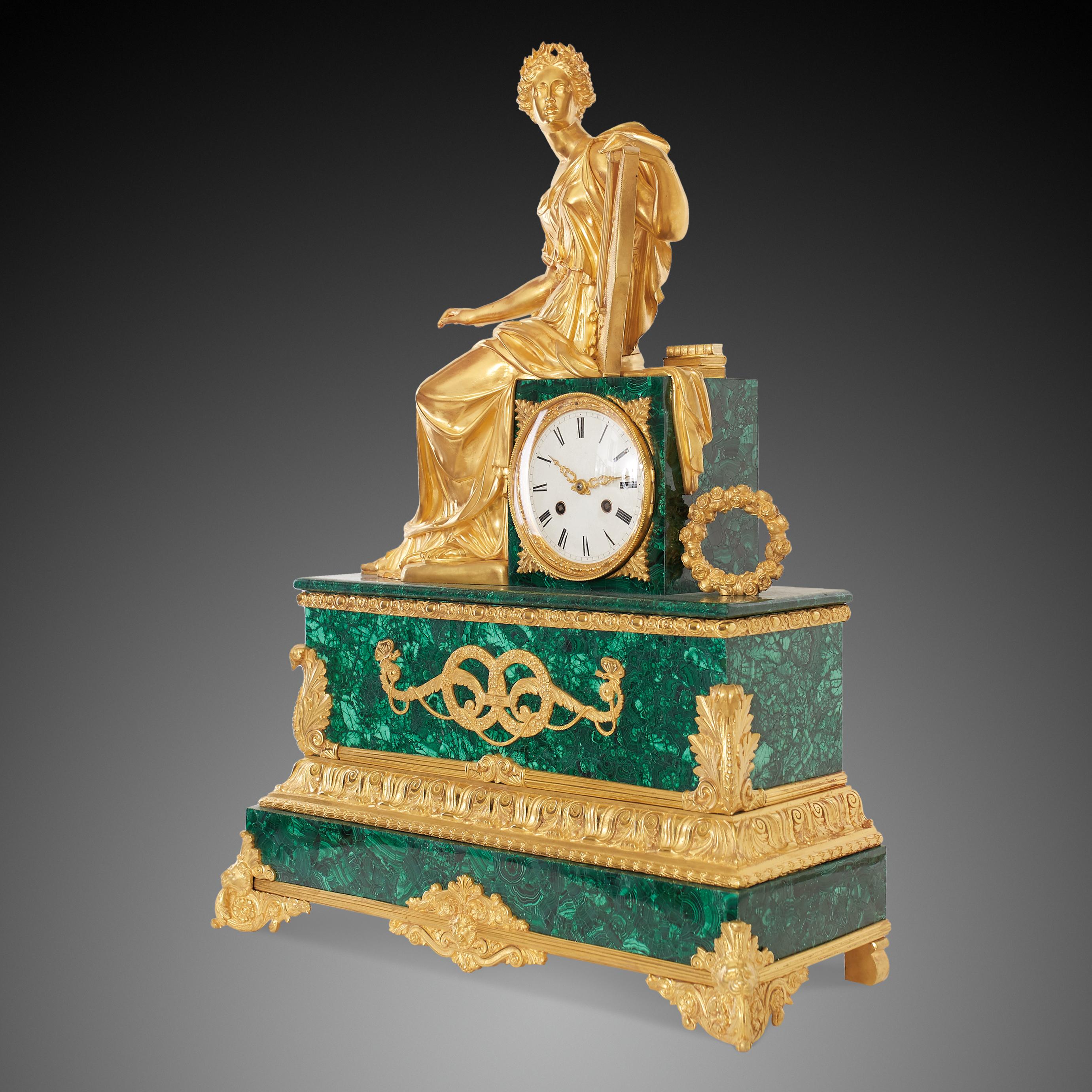 A magnificent malachite and bronze clock. in which Apollo is sitting on the top of it.
Apollo the god of nowledge, oracles, purity, art, music (he directed the choir of the Muses), poetry, archery (but not for war or hunting) and plagues, and also