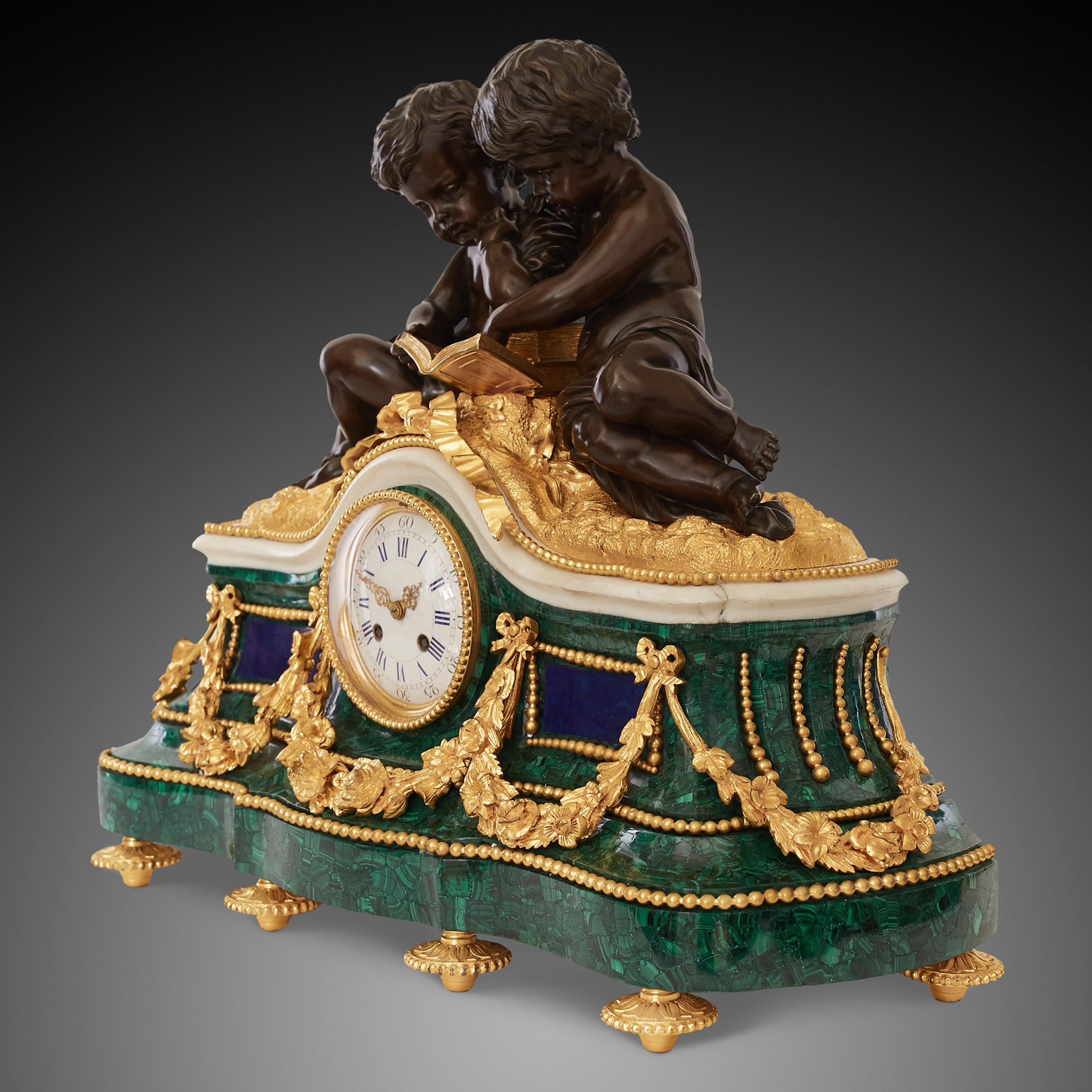 Antique late 19th c. French mantel clock crafted in Louis XVI style richly ornamented with ormolu flower garlands, bows and beaded lines all around the clock’s case. The main feature of this mantel clock is two putti figures reading a book made with