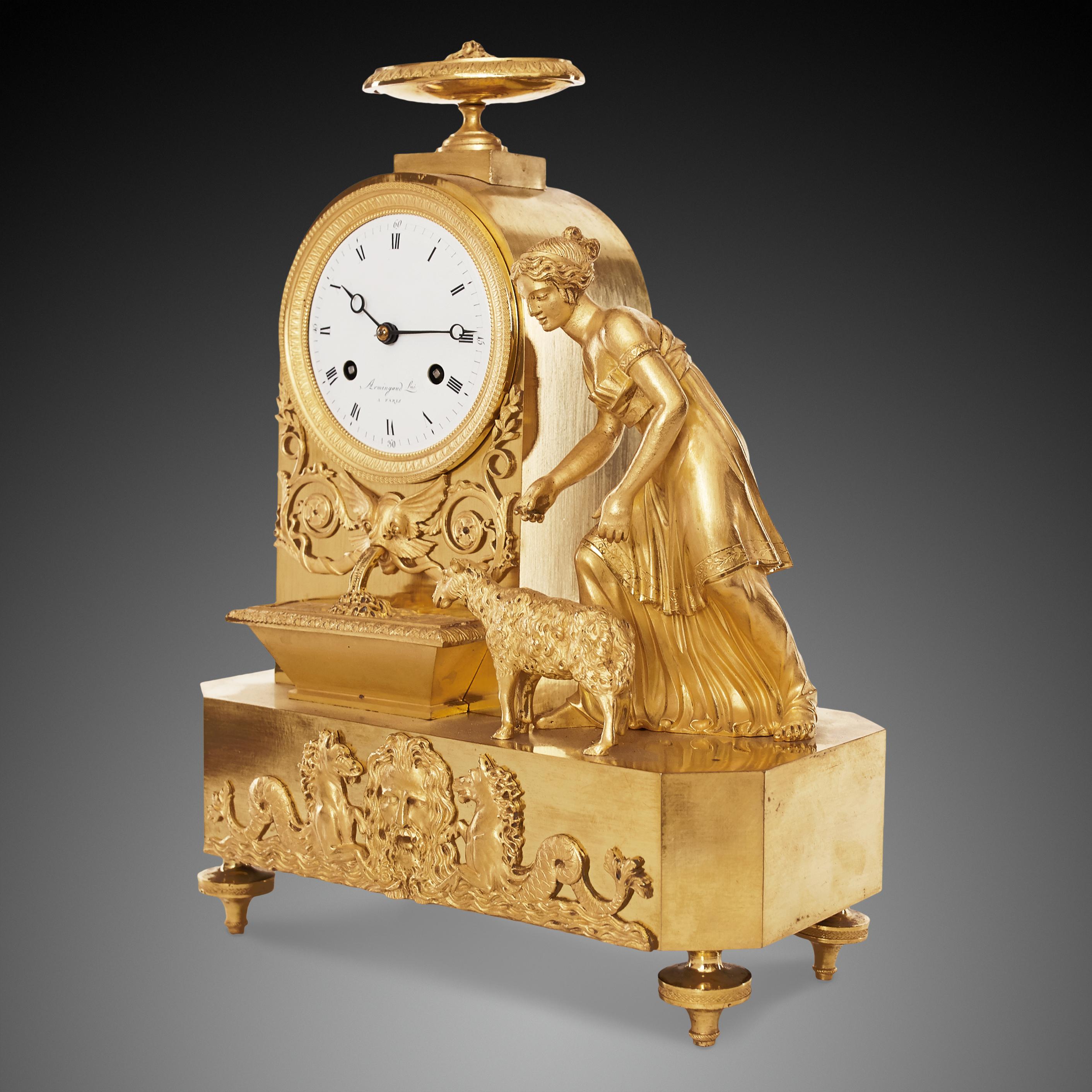 Early 19th century Empire clock crafted of gilt bronze, or ormolu, featuring a shepherd girl is feeding her sheep by the fountain. Below is the face of the sea god Poseidon and 2 mythical sea horses. The dial signed Armingaud a Paris
The clock