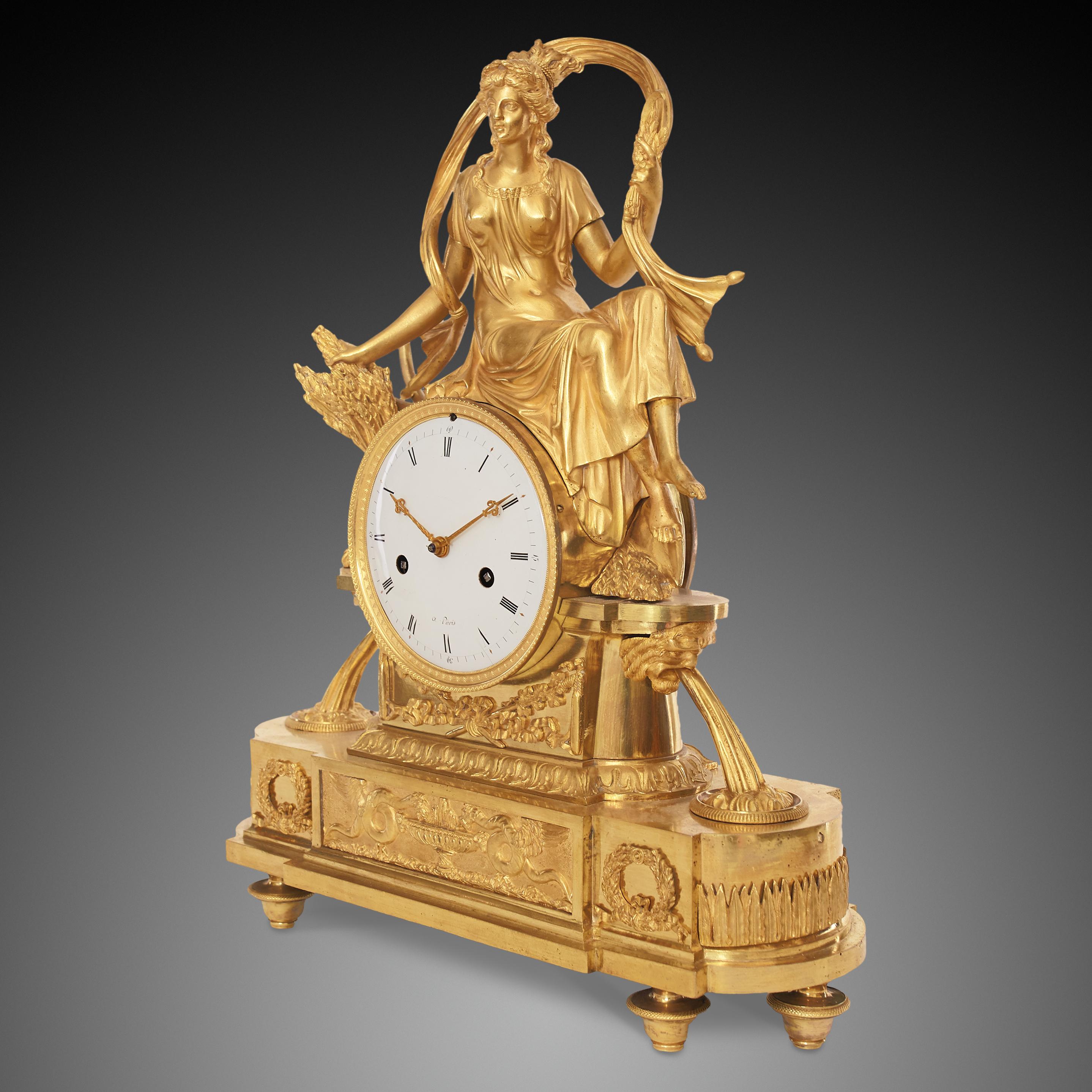 Empire-Uhr signiert à Paris 

Die Kaminuhr besteht aus vergoldeter Bronze und stellt Ceres als Göttin der Fruchtbarkeit, der Landwirtschaft, der Getreideernte und der mütterlichen Beziehungen dar. Im alten Rom wurde sie von den Menschen verehrt,