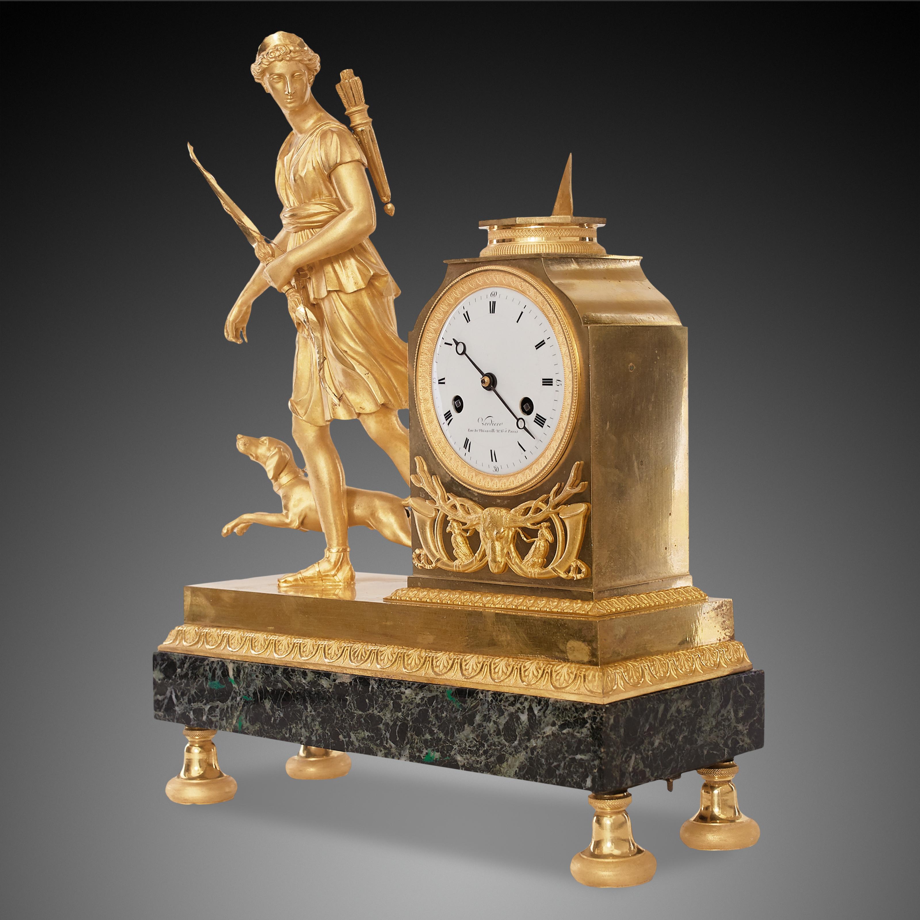 Profiled and finely chiselled disc feet with a tapered attachment. Rectangular green marble base with a palmette profile on top and a finely gilded, shiny base zone, with Diana walking with a dog on one side and the clockwork case on the other. This