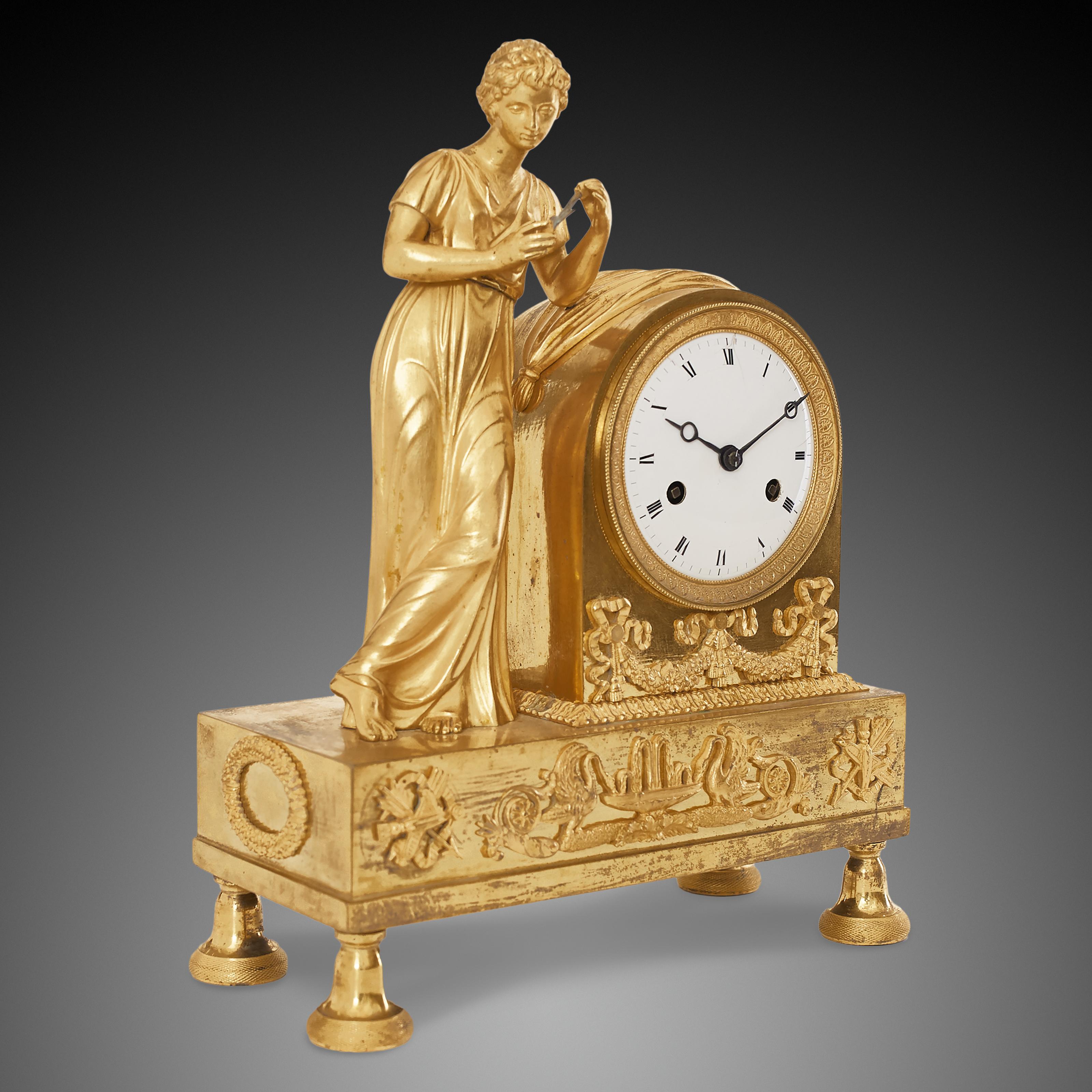 Empire style figural mantle clock from the beginning of the 19th century. This mantel clock is known also as the “Allegory of love”, as the woman featured in this clock is holding onto what seems to be left of a Cupid’s arrow. The significance