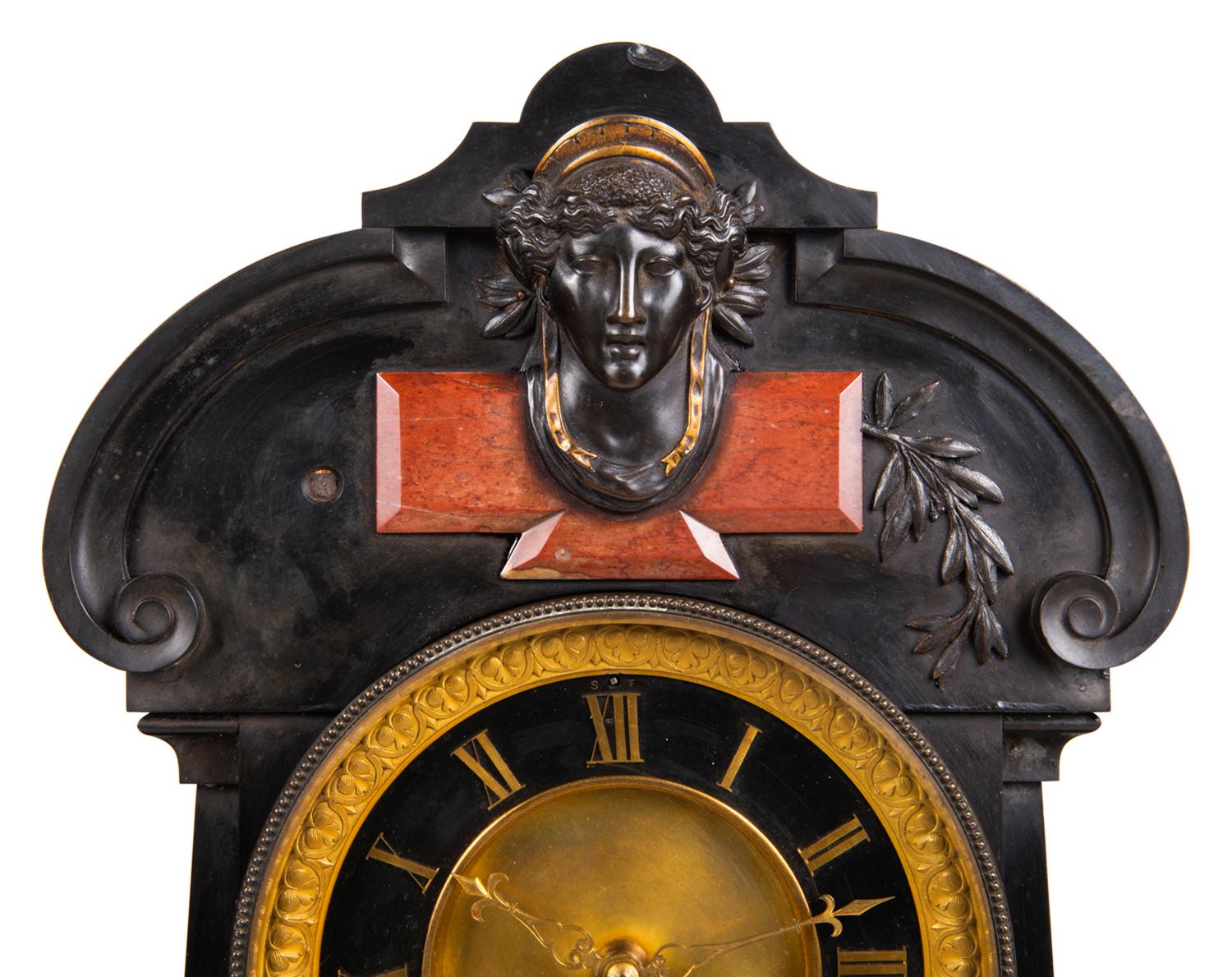 A very impressive 19th century Belgium black marble mantel clock with a clock, barometer and moon phase calendar, having classical scrolling decoration to the marble case, with inset rouge marble panels, a bronze mask and cherub holding a flame.