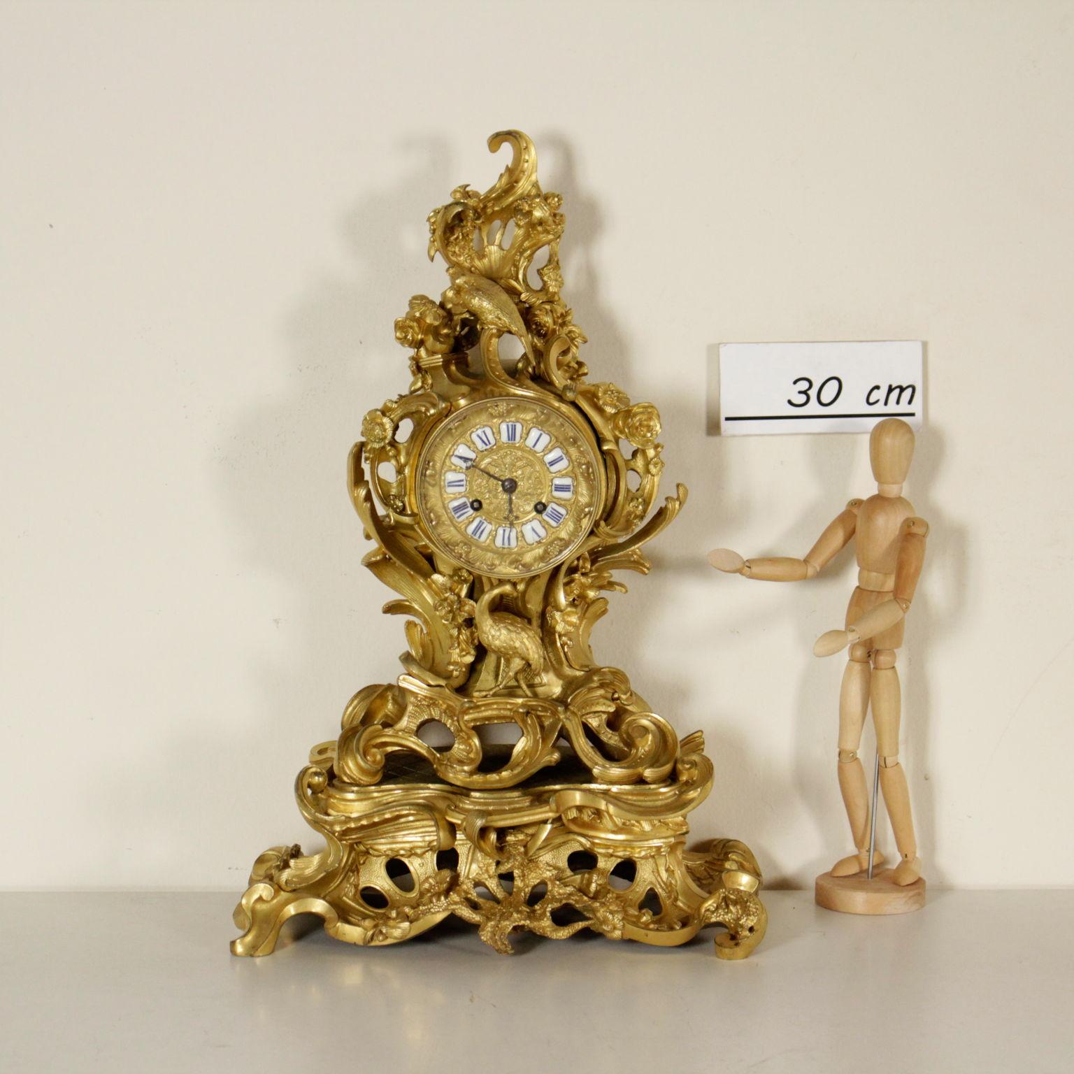 A mantel clock, Rococo style, chiseled and gilded bronze. Wide basement with volutes, foam, vegetable and animal motifs. Bronze face with Roman numbers drawn on glazed metal. Iron handles, finely perforated. Mechanism branded 'Pons 1927'.