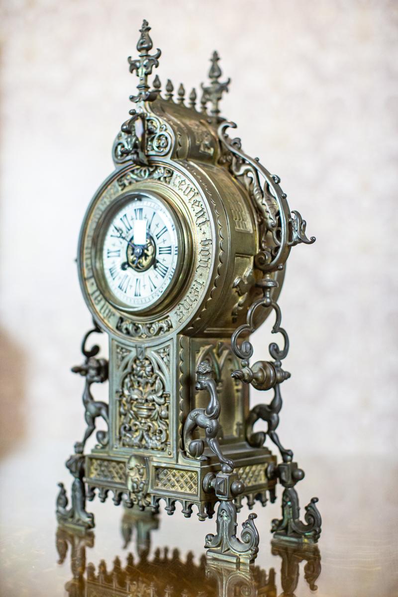 Mantel Clock in Decorative Metal Case, circa 1900

The metal case is decorated with floral and animal motifs. The porcelain clock face is covered by glass.
A French inscription can be found on the case: “Mal tems passe, revient bon tems.”

The