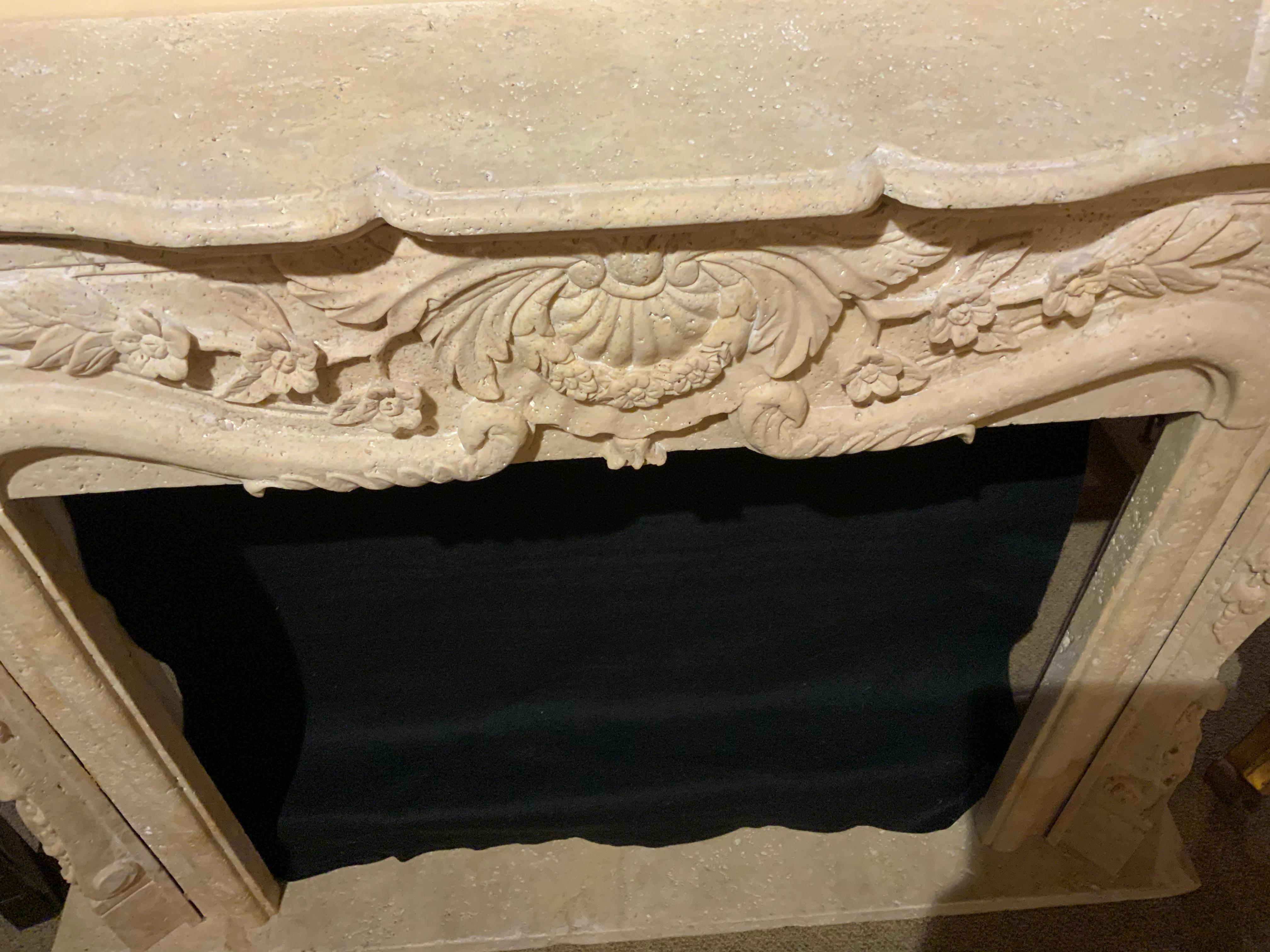 Travertine mantel with curved and carved corners, having a scalloped top edge
Center front with a shell cartouche centered with floral and foliate designs.
The corners having a graceful curved support.