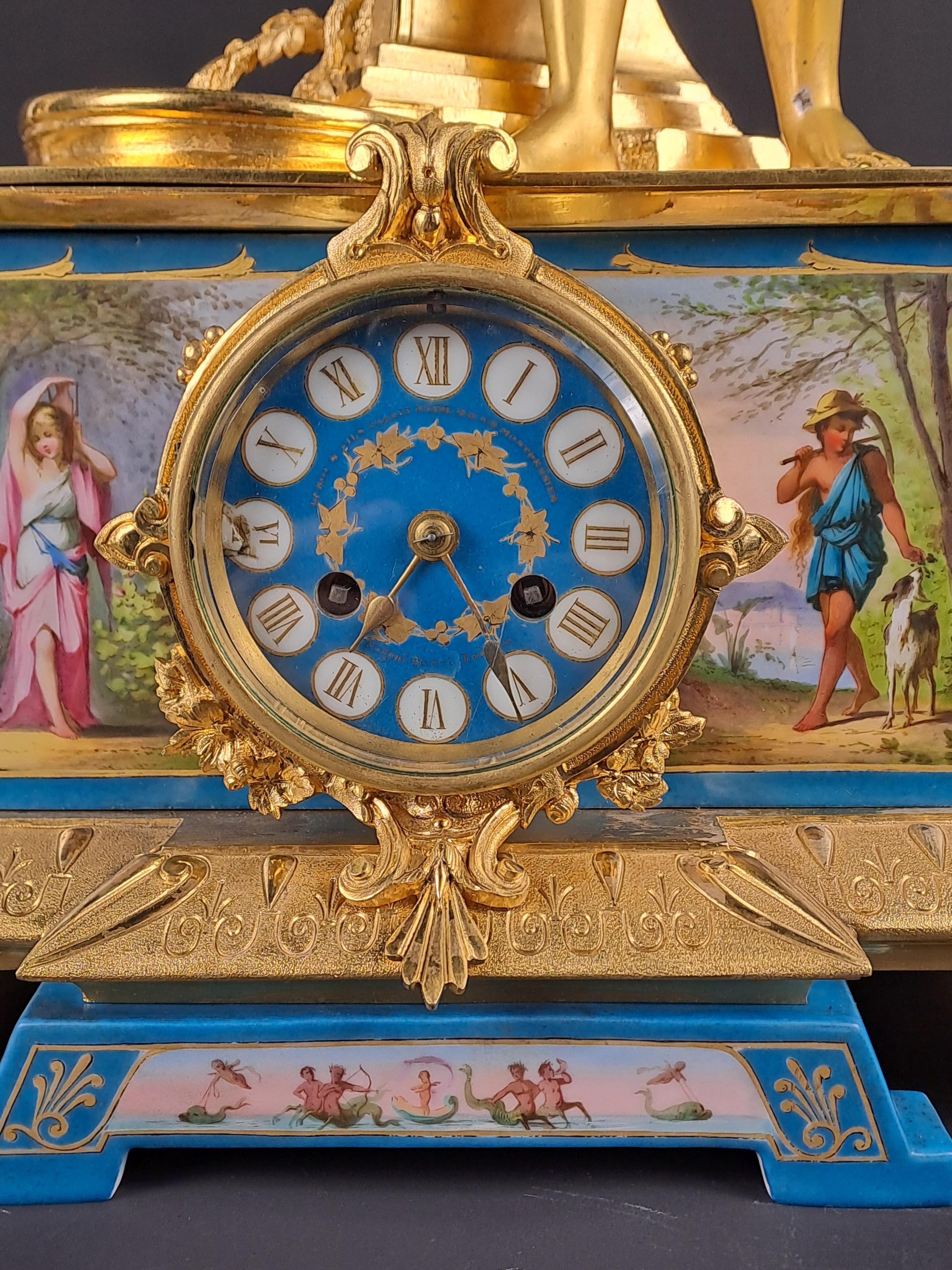 Magnificent Napoleon III period fireplace set in very finely chiseled gilded bronze and Sèvres porcelain painted with animated scenes.

Composed of a large clock with neo-classical decoration depicting a man leaning on a fountain holding a pencil in