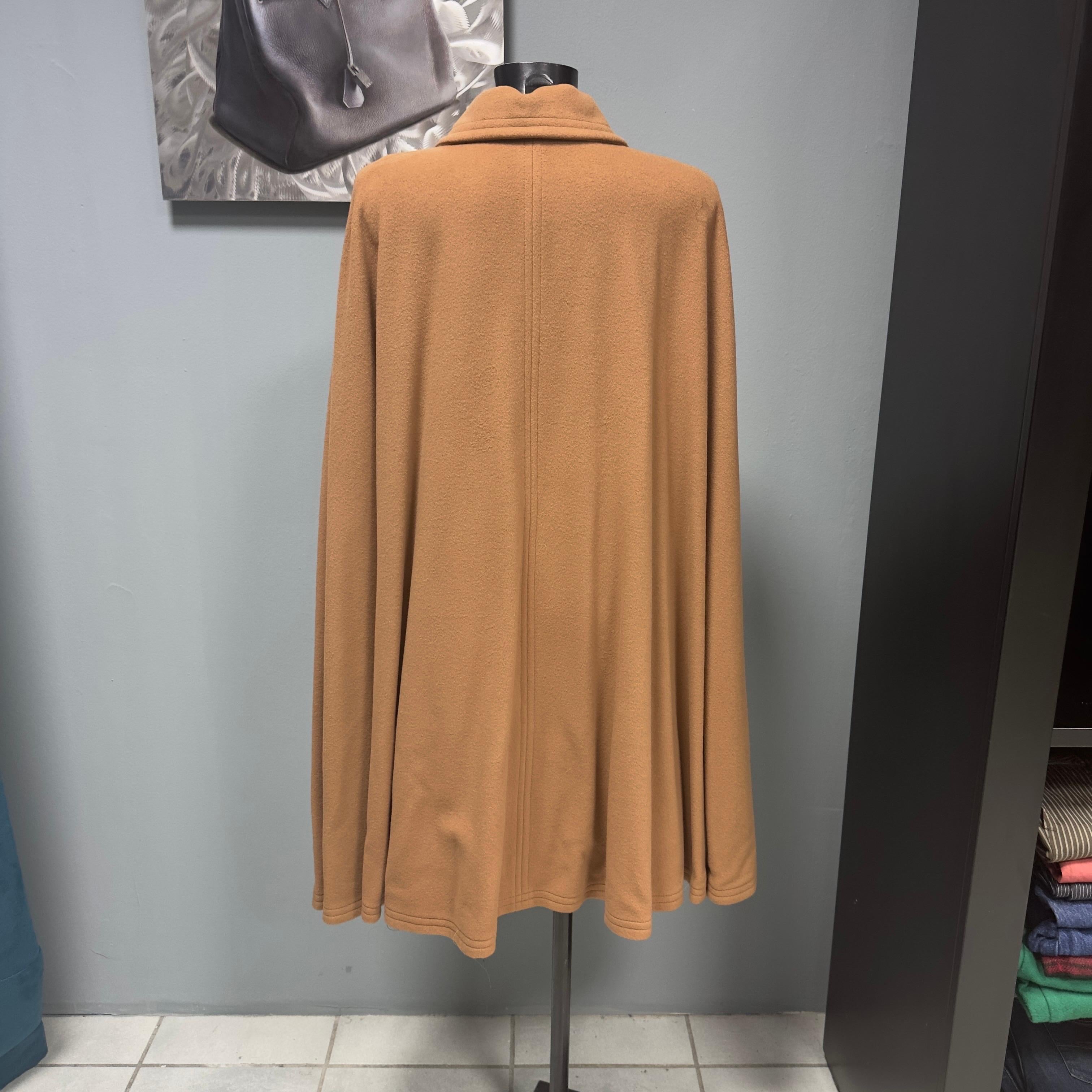 Mantella Yves Saint Laurent con colletto e chiusura un bottone.
Color cammello, perfetta con tutti gli outfit, adatta a diverse taglie. 
Rifiniture bordate, mai utlizzata
Taglia 38 fr, 100% Lana
Lunghezza 89cm
