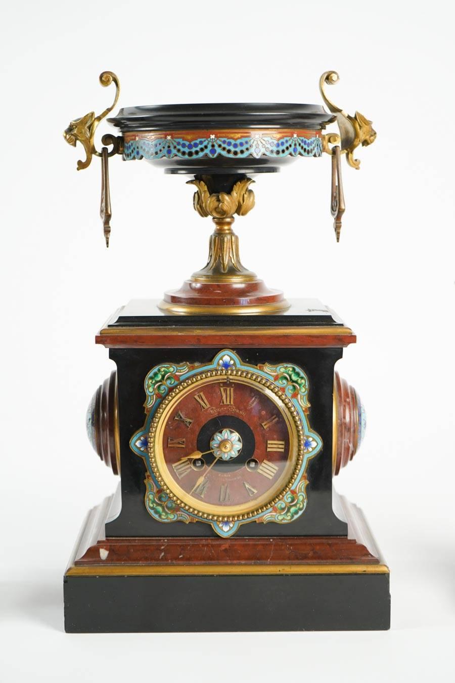 Mantle clock Napoleon III. Eugene Cornu enamel, cherry and black Belgian marble with gold gilt bronze. Paris. 1870 - 1880. 
Pendule: H 40cm, L 23cm, P 16cm
Cassolettes: H 24cm, D 18cm.