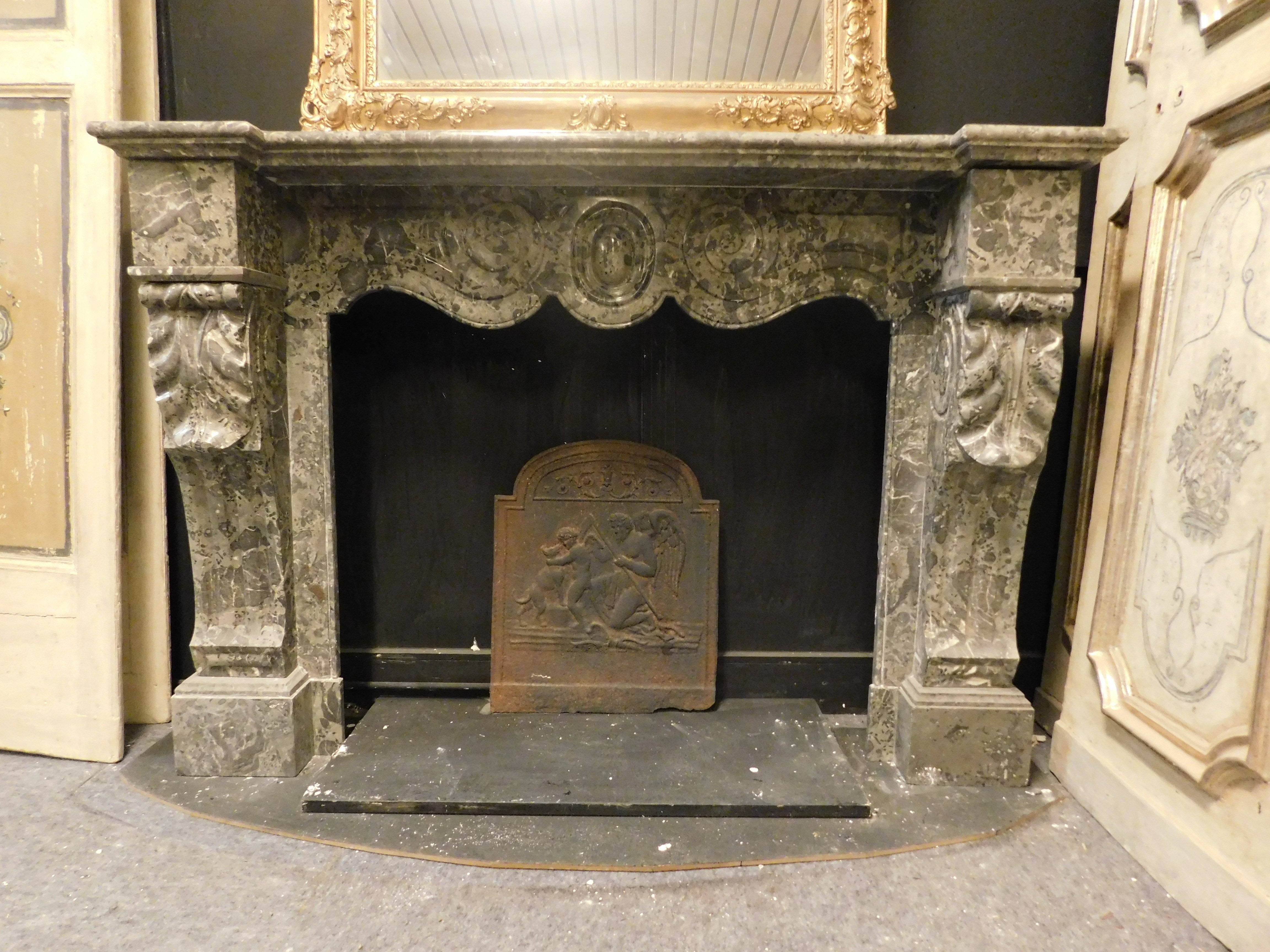 Cheminée ancienne en marbre gris veiné, sculptée à la main avec des formes nettes et ondulées, une bouche ondulée et des feuilles d'acanthe sculptées sur les côtés. Original du 19e siècle, originaire d'Italie.
Dimensions extérieures Maximum cm w 152