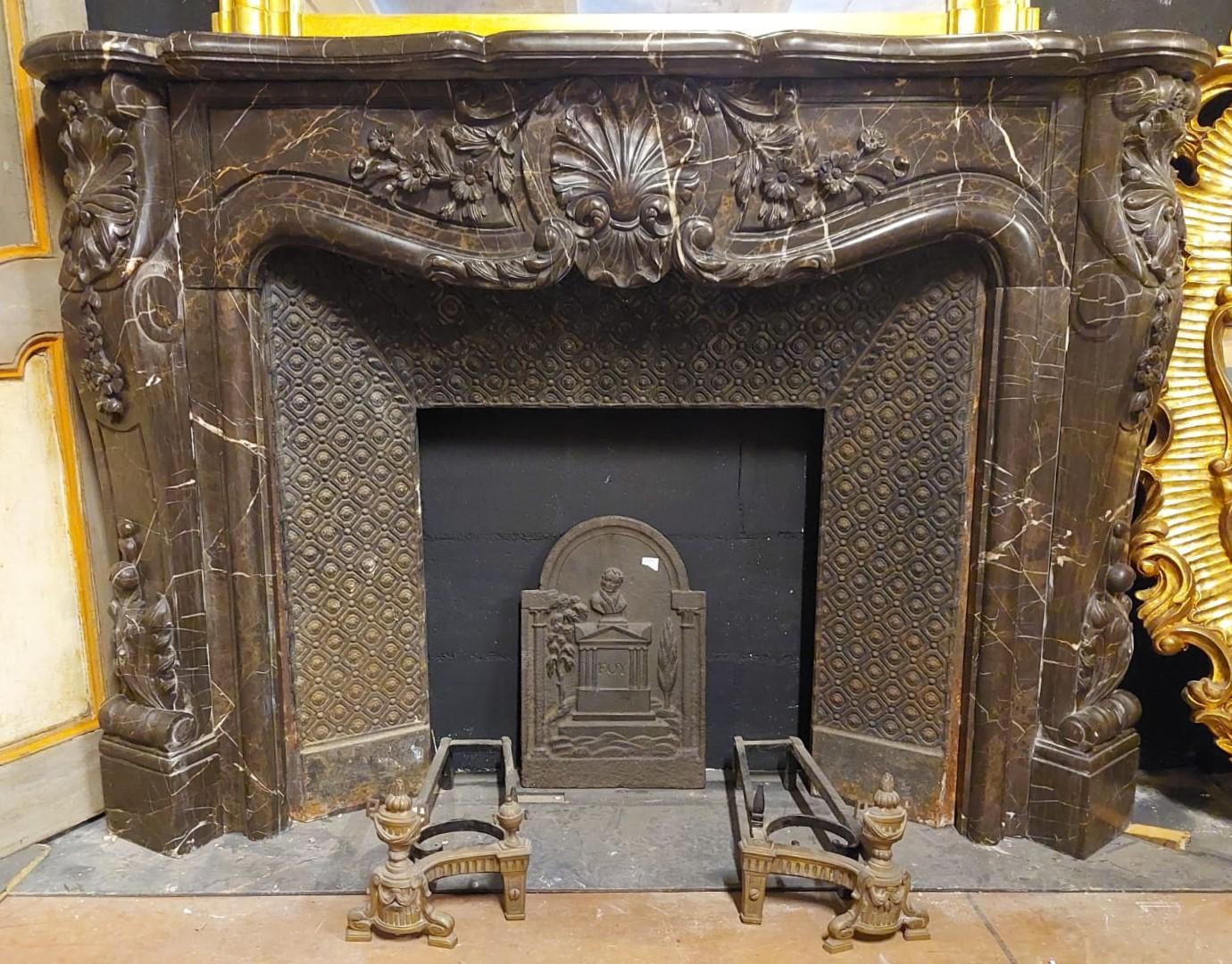 Antique fireplace mantle in black marble, richly carved by hand with central shell and leaves / flowers typical of the time, built by a craftsman in the late 19th century in Italy.
Very rich and of great stage presence, elegant and refined,