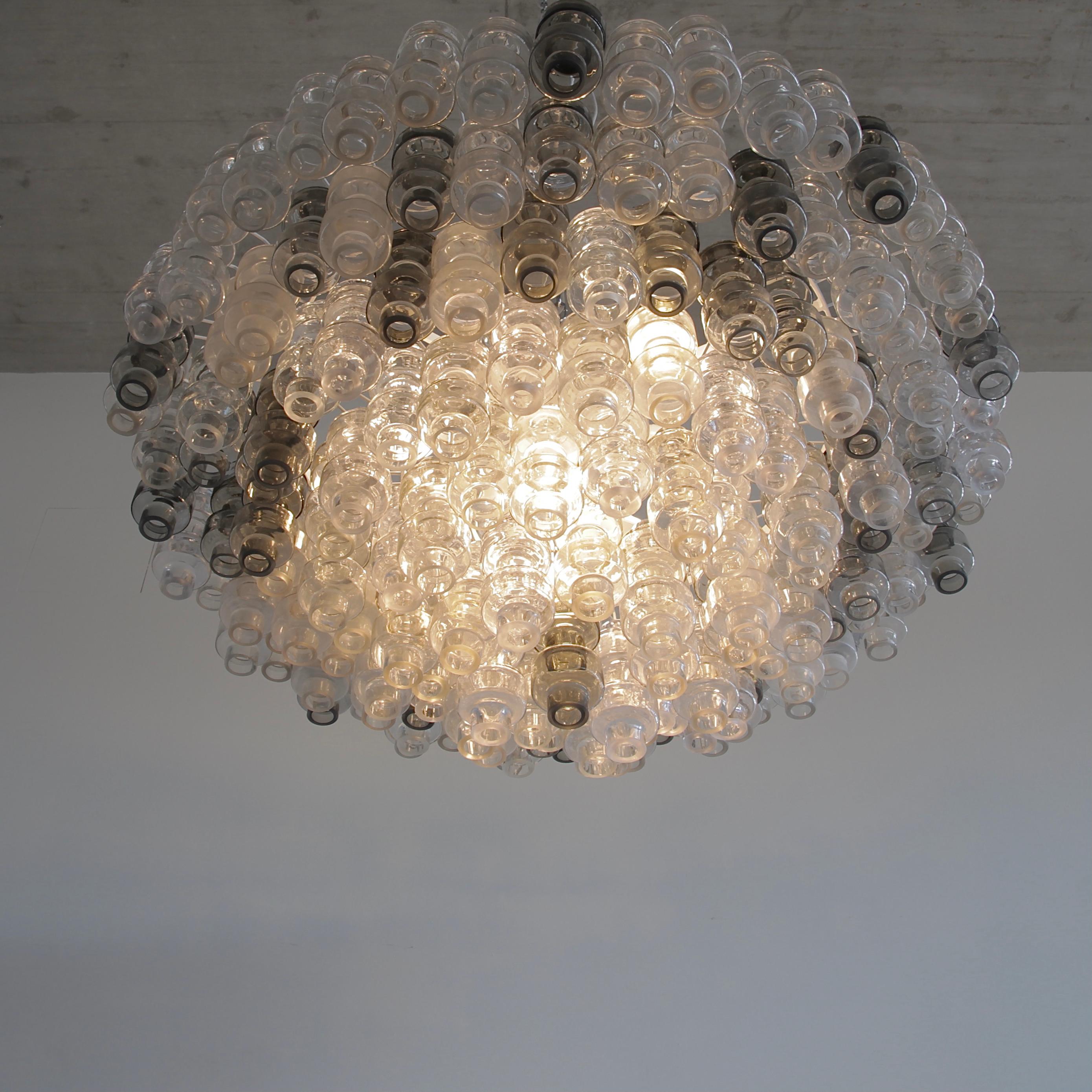 Large Manubri glass chandelier, Murano, Italy.

Chandelier with moulded 'Manubri' glass pieces in a variety of shades. Clear, slightly tinted and smoked glass pieces are available.

White metal structure, chrome chain and ceiling cover and well