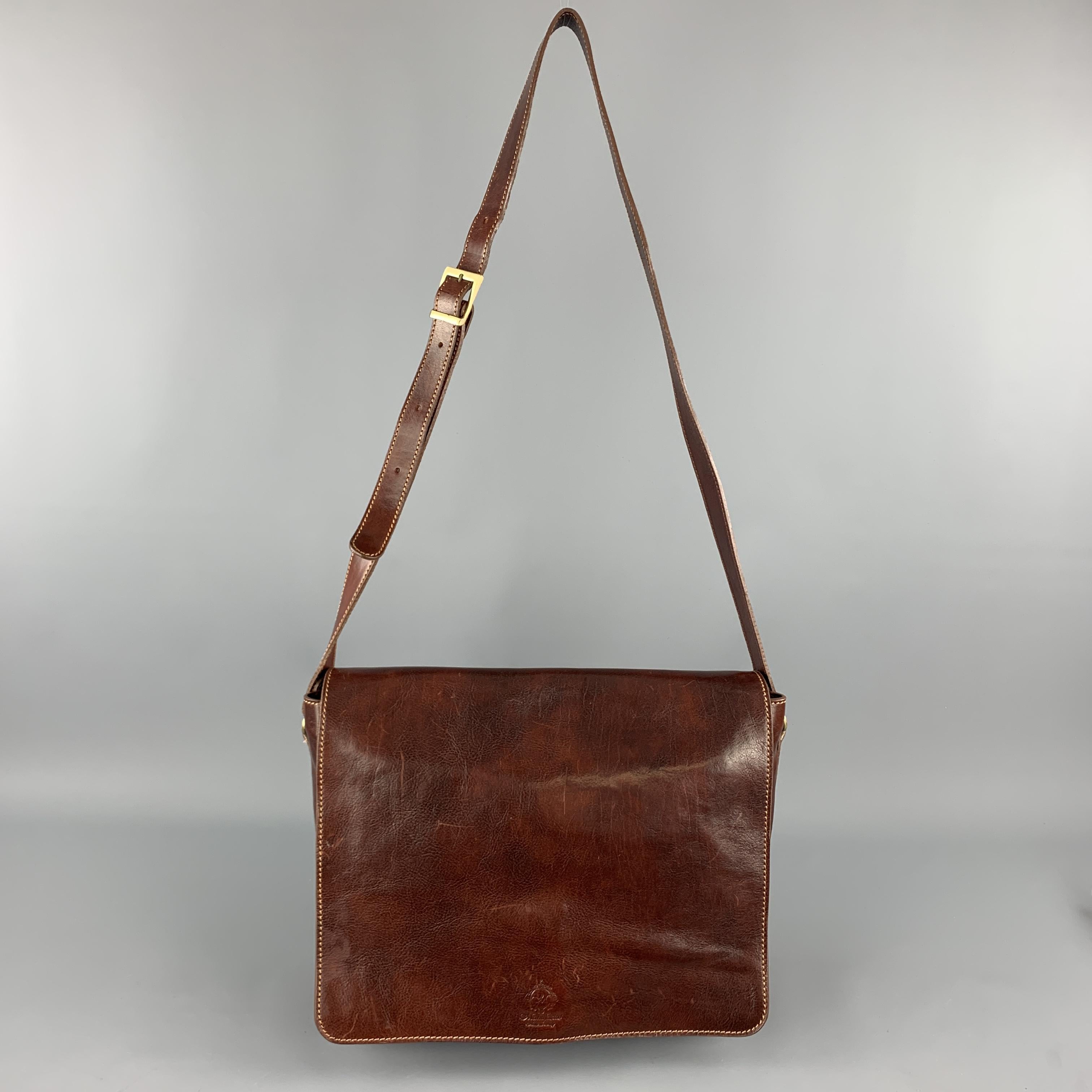 MANUFACTUS messenger bag comes in cognac leather with an embossed flap with inner press lock closure, adjustable strap, inner compartments with pockets. Made in Italy.

Very Good Pre-Owned Condition.

Measurements:

Length: 14.5 in.
Width: 4