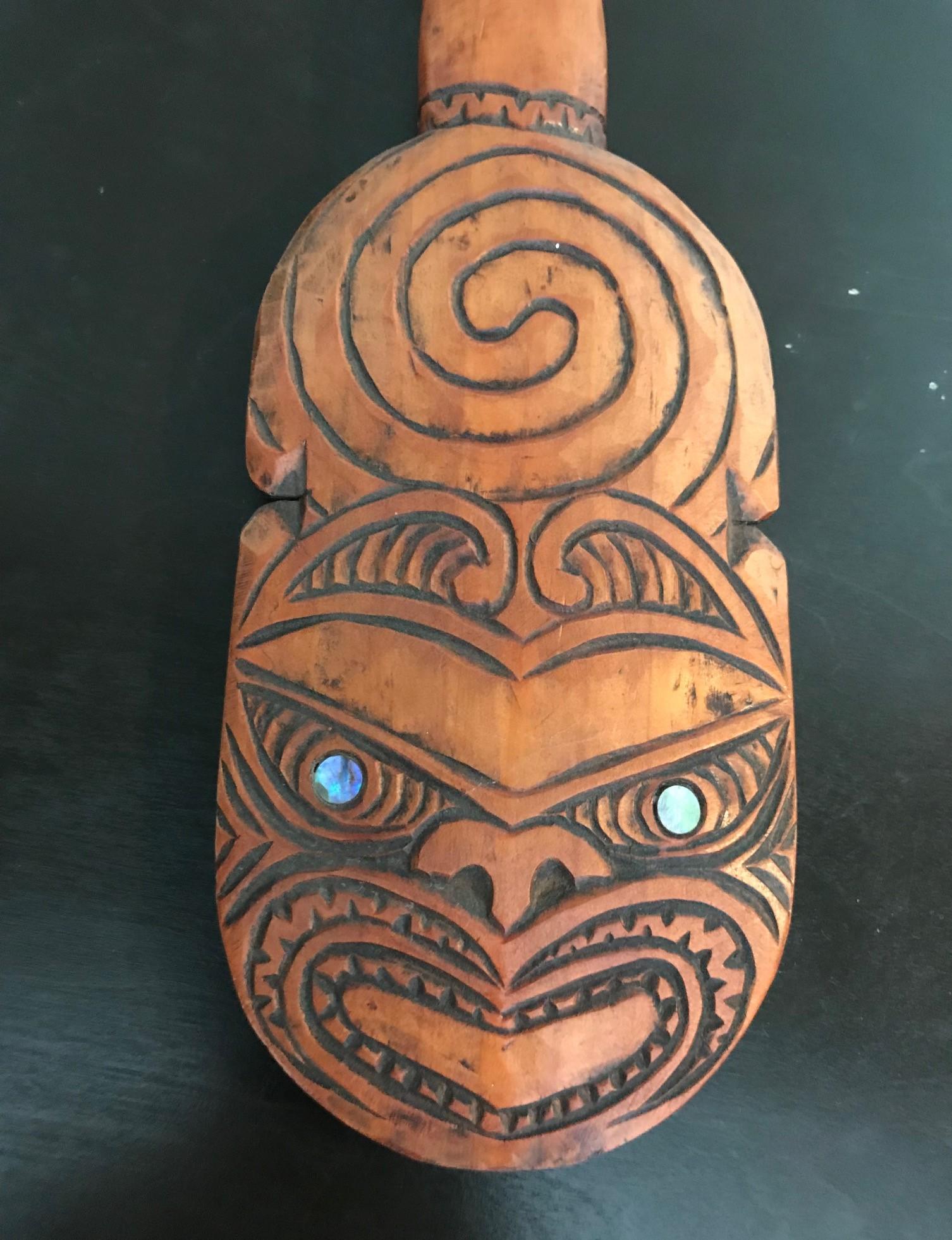 Great piece made by the Maori People of New Zealand. Hand carved and decorated. 

A patu is a club or pounder and was originally designed and carved from wood by the Maori people as a weapon to strike, hit, beat, or subdue their opponents. This