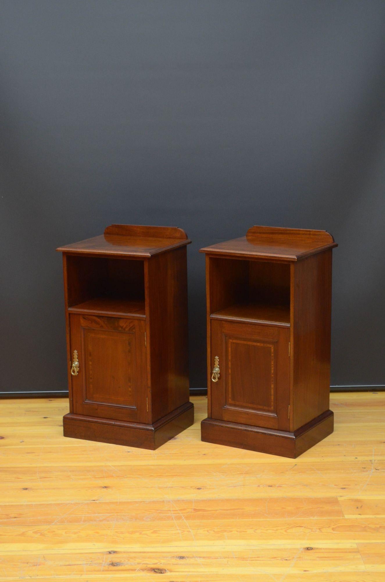 Sn5466 Fine quality matched pair of Edwardian mahogany bedside cupboards, each having shaped upstand to the back edge and crossbanded top with moulded edge above open storage space and panelled cabinet door fitted with brass handle and enclosing a