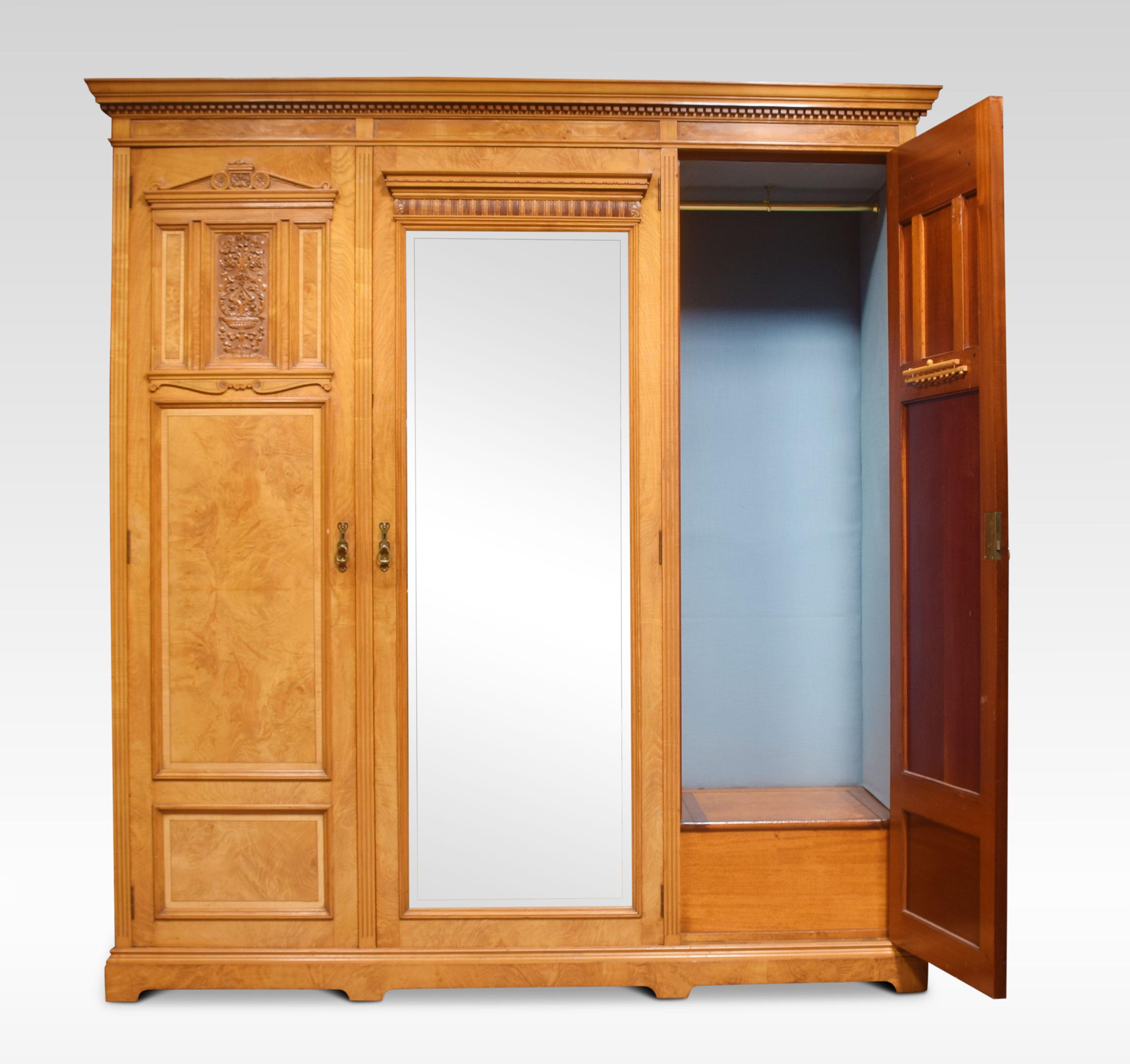 Maple and Co wardrobe, the dentil moulded frieze above a large central beveled mirror door opening to reveal a fitted interior, flanked by two paneled doors with crisply carved leaf decoration. Opening to reveal a large hanging area. All raised up