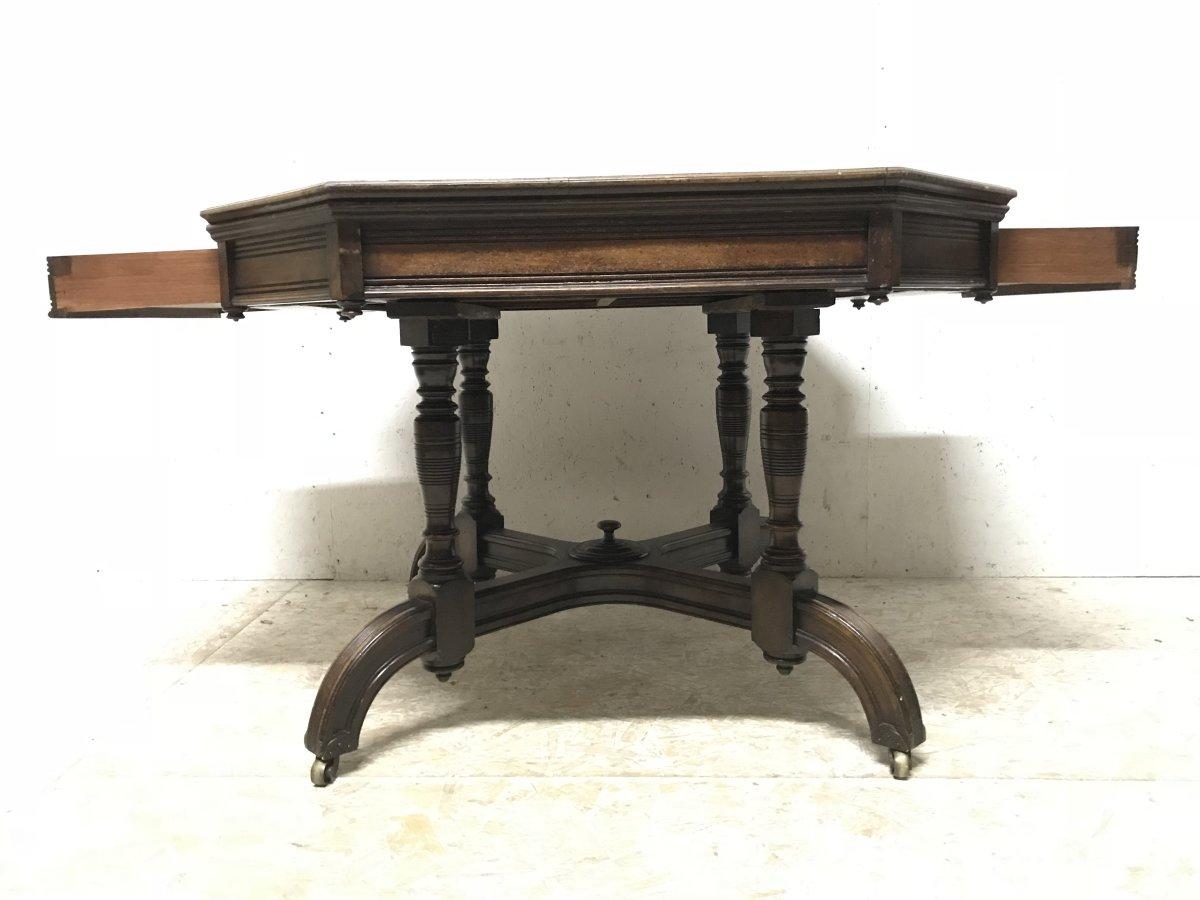 Maple & Co. a fine quality Gothic Revival oak leather top writing or centre table with two side drawers, both retaining the original brass handles and escutcheons, the top supported on four turned legs united to a cross form base with arched feet,
