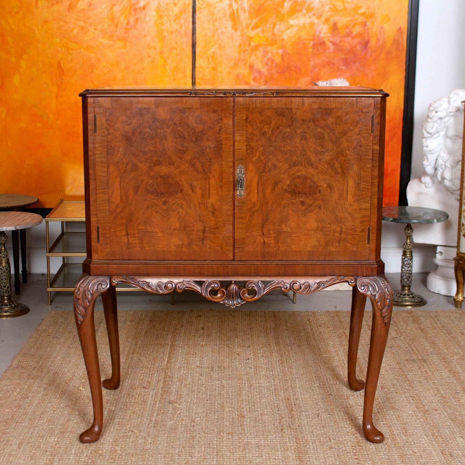 A fine quality burl walnut cocktail cabinet by Maple & Co.

The inset glass top bordered by well carved chamfered edges. A pair of fine quality marquetry panel doors enclosed a fabulous fitted interior briefly comprising galleried shelves,