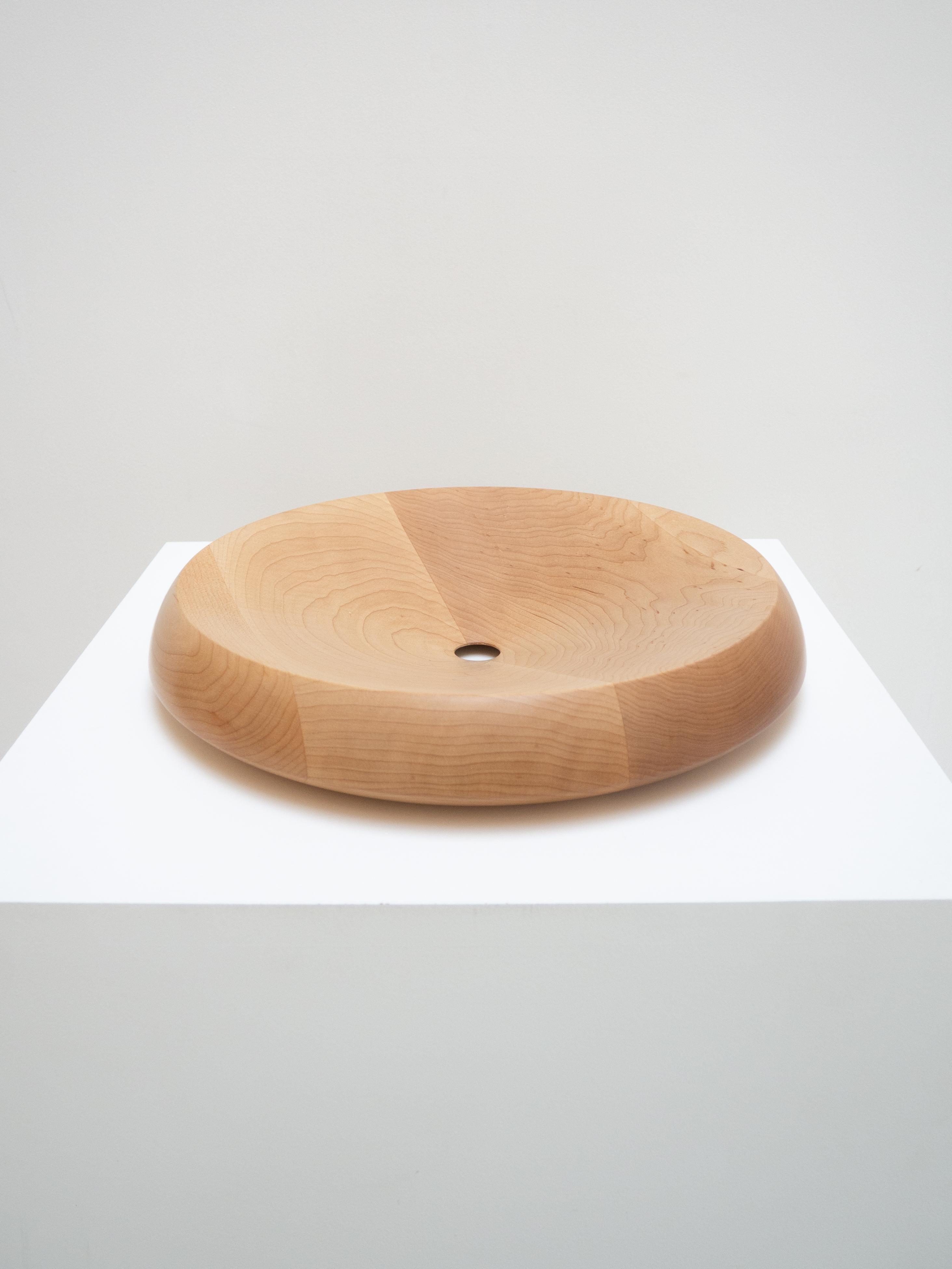 Designed by Peter de Jong, this large maple bowl captivates with its precise lines. The wood grain is accentuated by an opening at the bottom of the bowl, which adds a subtle and unexpected graphic detail.