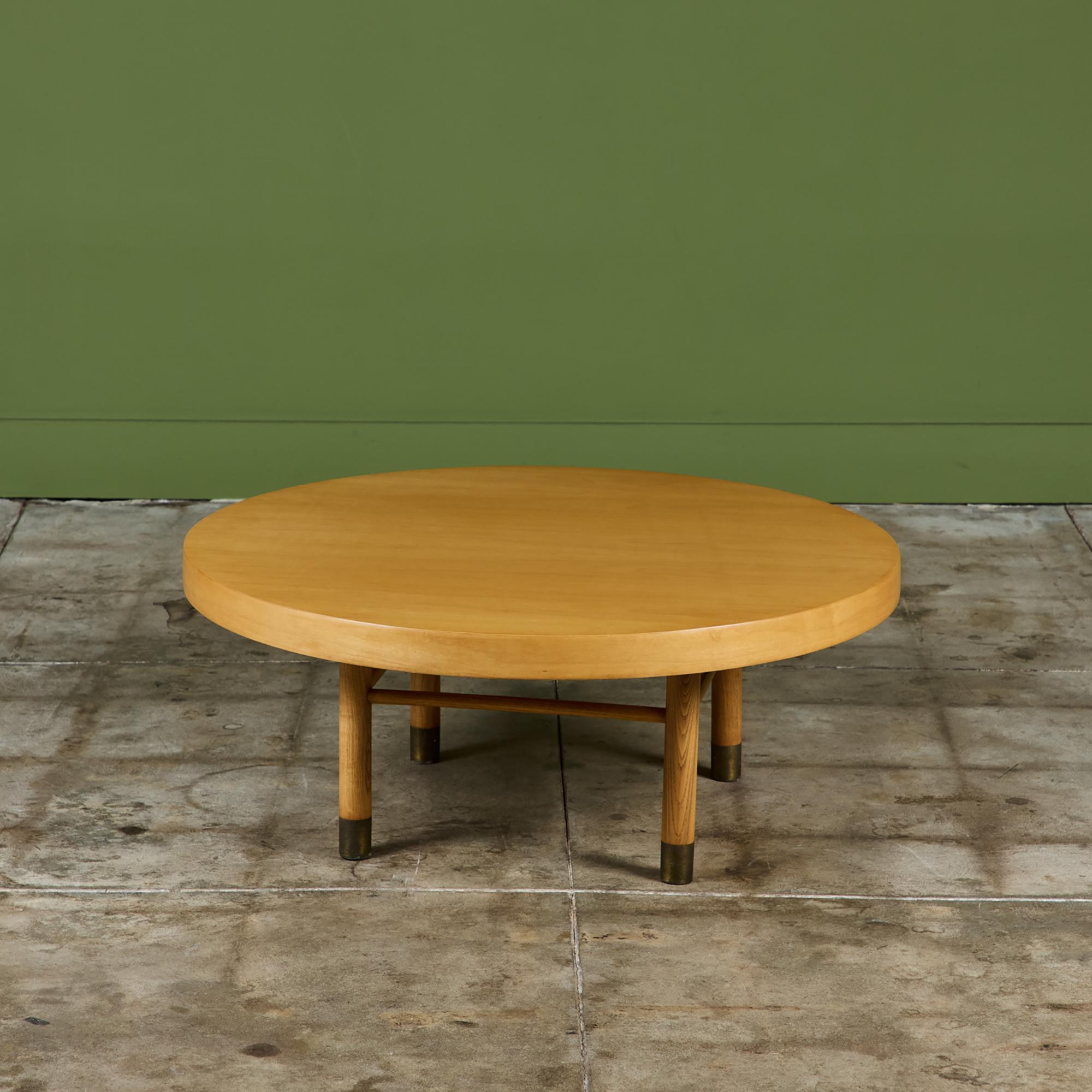 Round coffee table by Carlin Furniture, c.1957, USA. This beautiful maple table features a round table top with lazy Susan mechanism allowing the entire table top to rotate. It is supported by four tubular wood legs with brass capped
