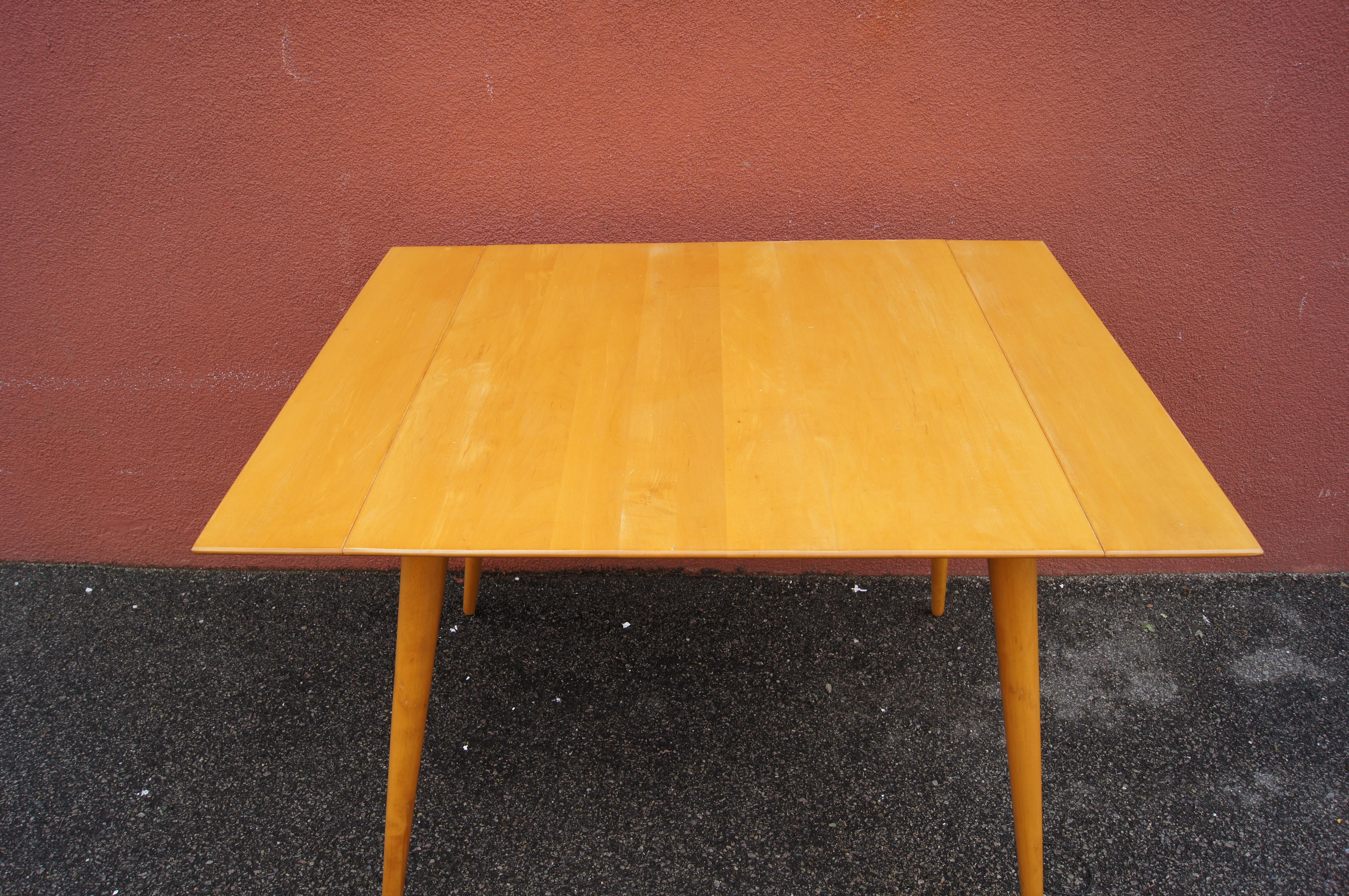 Paul McCobb designed this midcentury dining table, model 1521, for Winchendon. The outer edges of the tabletop slide open to accommodate two 10-by-30-inch leaves that extend the table's width to 60 inches. The maple frame features the splayed,