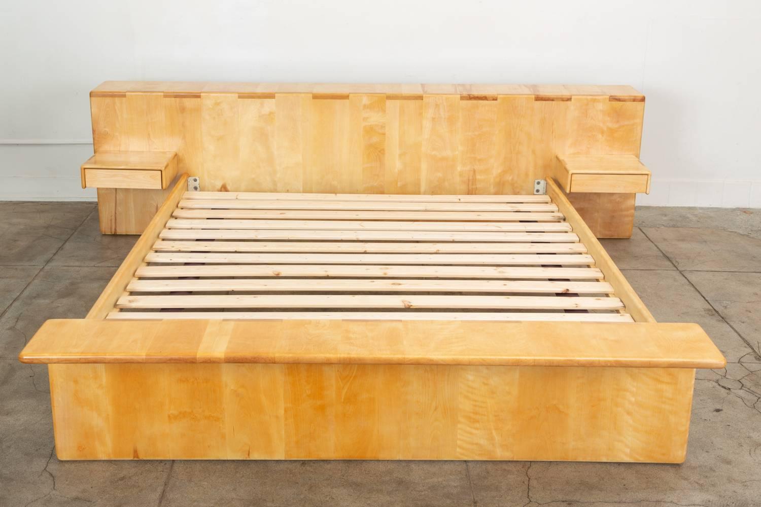 A generously proportioned platform bed by California designer and woodworker Gerald McCabe for his company Erin Furniture. This example in solid maple with wide box joints has two floating nightstands and fits a California King mattress. The wide