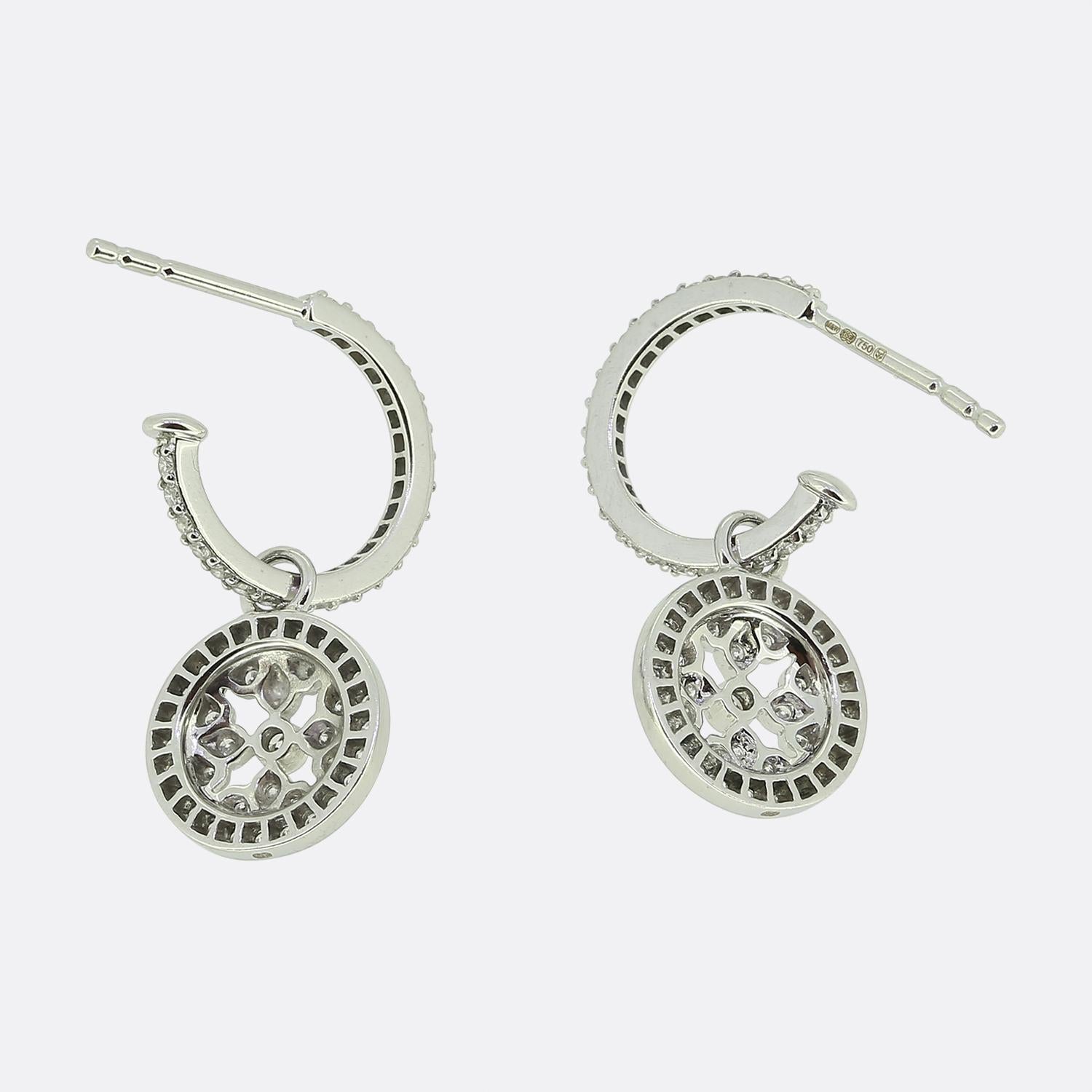 Here we have a sophisticated pair of drop earrings by Mappin & Webb. The earrings are crafted from 18ct white gold and feature a circular design, intricately adorned with round brilliant-cut diamonds set in a delicate pattern, creating a captivating