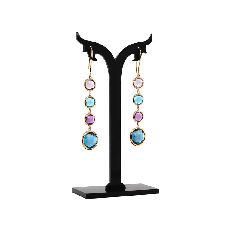 These gorgeous drop earrings created by British jewellery designer, Mappin & Webb are from their discontinued Malleny Collection. They feature four round faceted gemstones, two amethysts and two blue topaz stones all rubover set in fine 18 carat