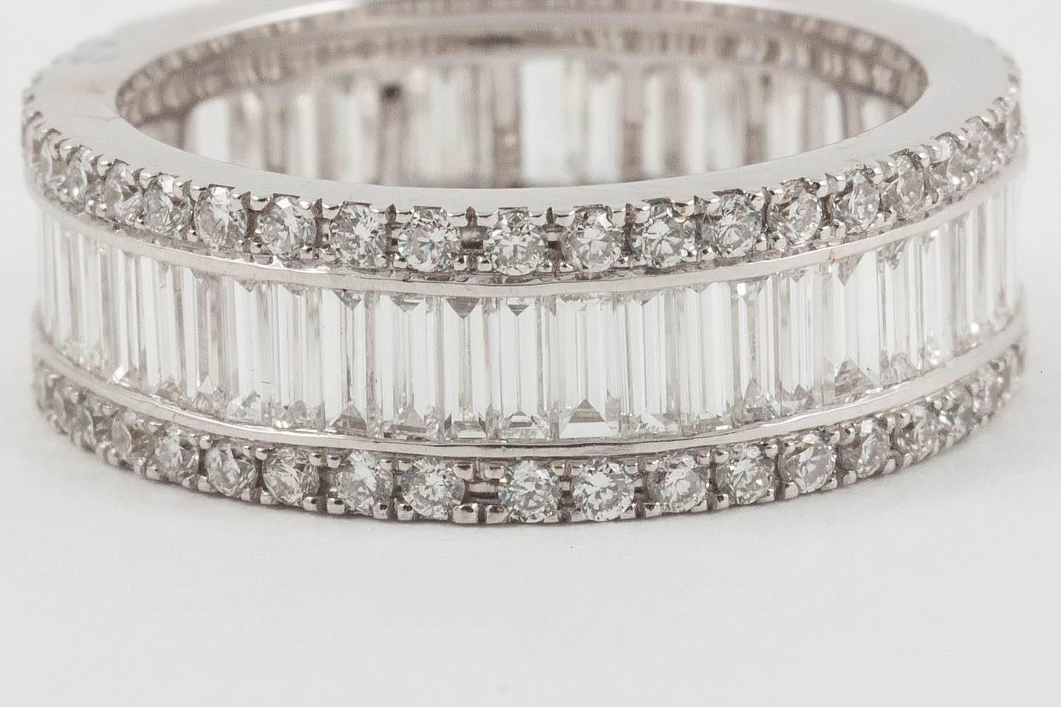 The classic Mappin and Webb triple eternity ring in UK L 1/2 (US size 5 7/8) with 3 bands of diamonds. The small round brilliant cut diamonds topping and tailing a line of baguette cut diamonds. The whole mounted in platinum. The diamonds are